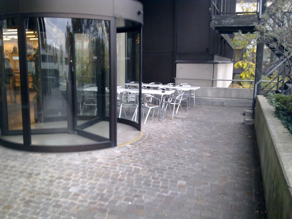 Y22-G, Balkon/Terrasse: Sicht auf die Terrasse. Auf der linken Seite ist die Drehtüre zu sehen. Diese Drehtüre ist der direkt Ausgang vom Café Seerose hinaus auf die Terrasse. Bei der Drehtüre hat es jedoch eine Stufe.