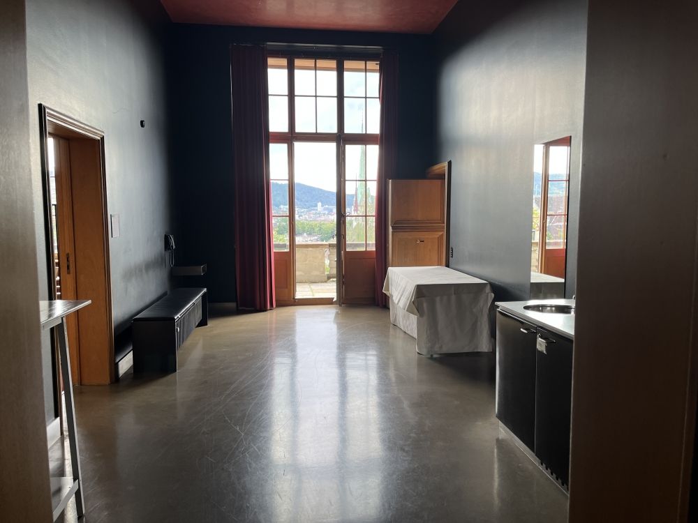 Aufenthaltsraum KOL-E-11: Vorraum (E-12).
Im Bild links befindet sich das Dozierendenzimmer. Geradeaus kann man auf die Terasse und vorne rechts geht es ins Senatszimmer (E-13).

In diesem Raum befindet sich auch ein Spühlbecken und eine Kaffeemaschine.