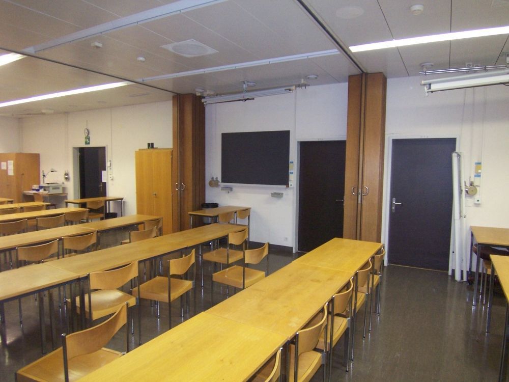 Seminarraum Y13-J-13: Sicht auf die drei Eingangstüren.
Ganz links im Bild ist der Raum Y34 J-01, in der Mitte ist der Raum Y13 J-13 und rechts der Raum Y13 J-11.
Die beiden Trennwände sieht man in der Mitte des Bildes.