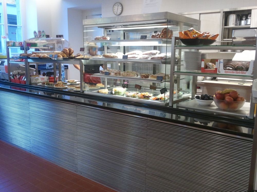 RAI-E, Cafeteria: Das Selbstbedienungsbuffet. Die Höhe des untersten Regals (Thekenhöhe) beträgt 90 cm, die Höhe des obersten Regals 155 cm.