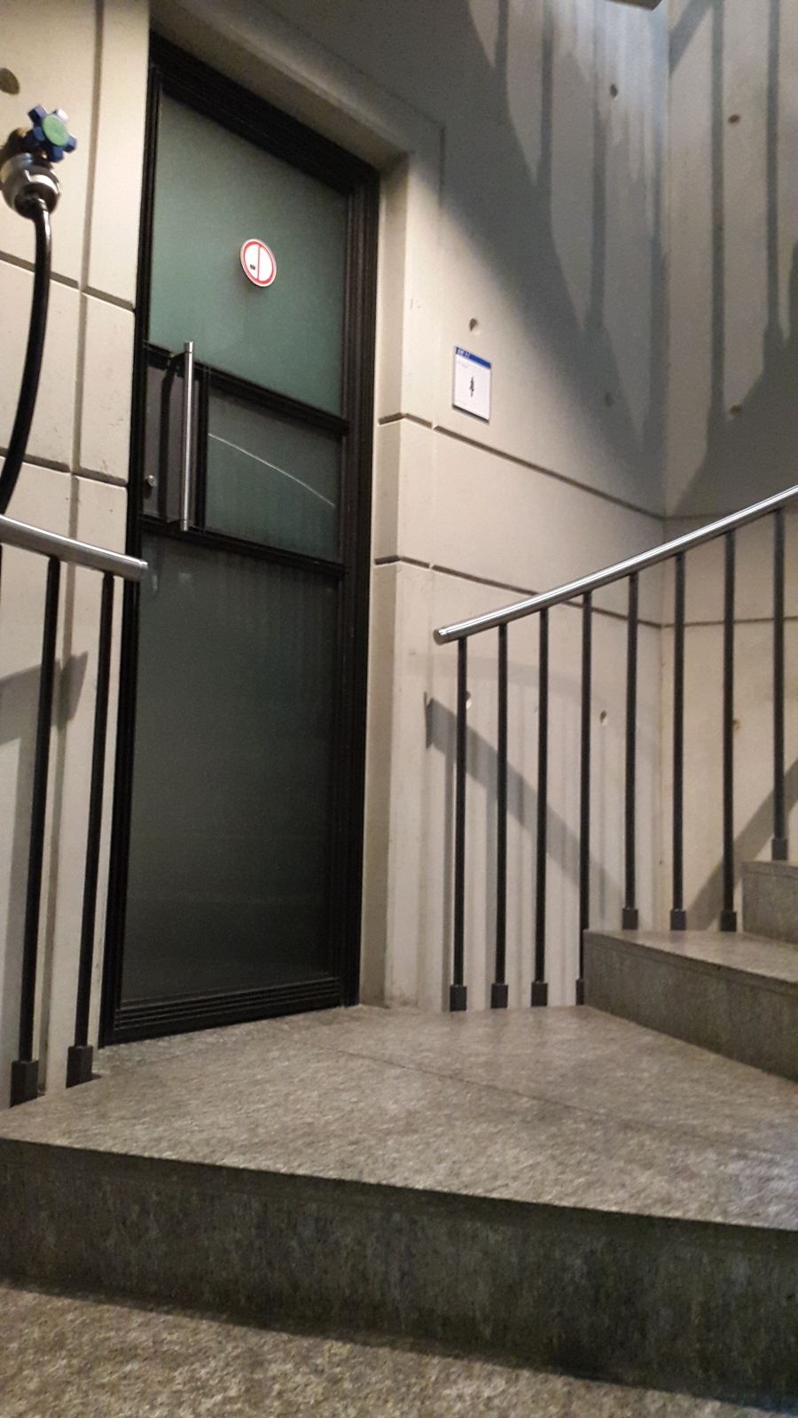 WC-Anlage ZUB-U-104: Diese Herrentoilette befindet sich auf der Treppe, die vom EG ins 1. UG fühft. Blick vom 1. UG in Richtung EG, die Treppe hinauf (Toillettentüre links).