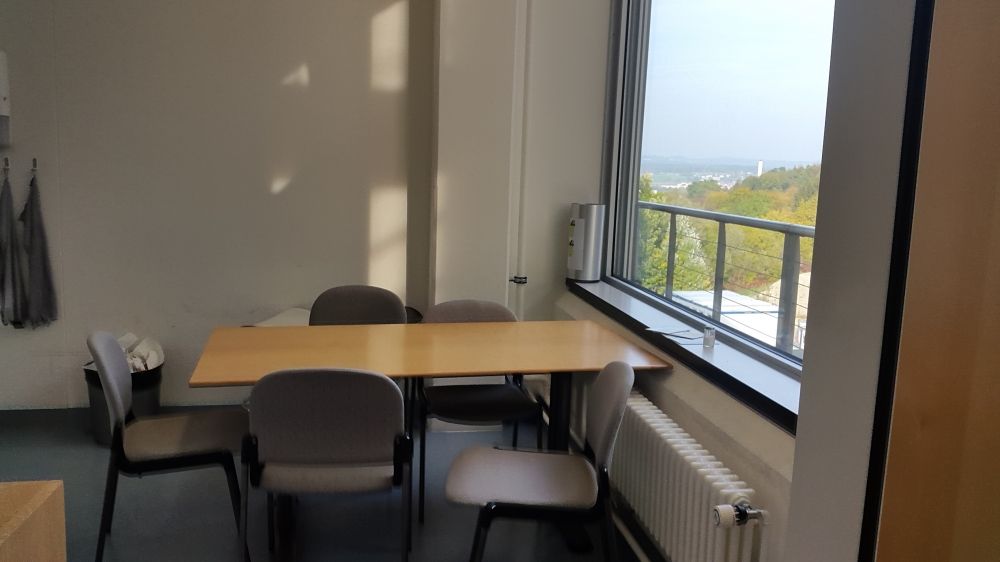 Aufenthaltsraum Y55-K-98A: Blick vom Eingang geradeaus. Auf der rechten Seite direkt nach der Eingangstüre befindet sich der Ausgang zum Balkon.