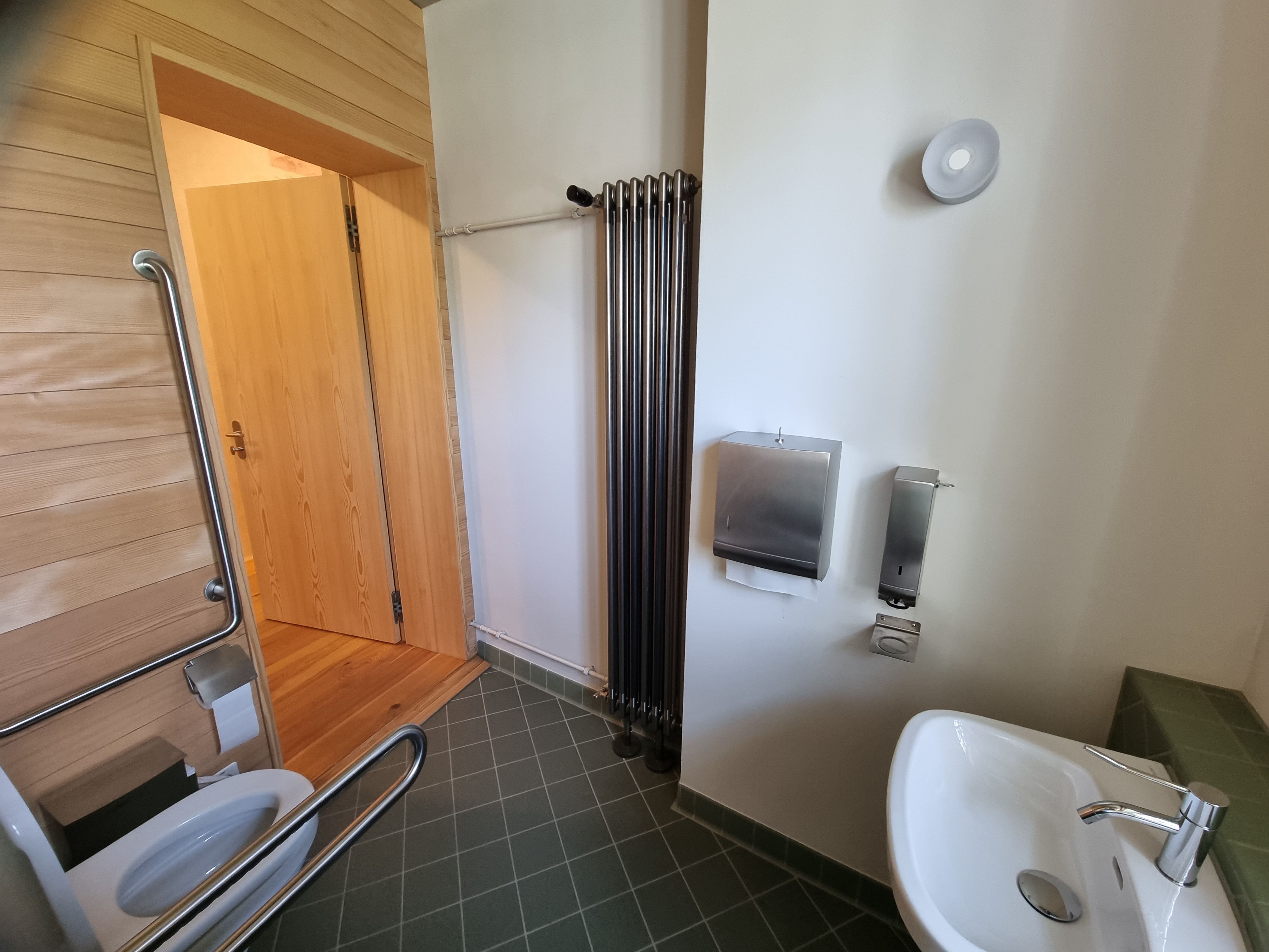 E-108: Bild des Rollstuhl-WCs vom Waschbecken aus.