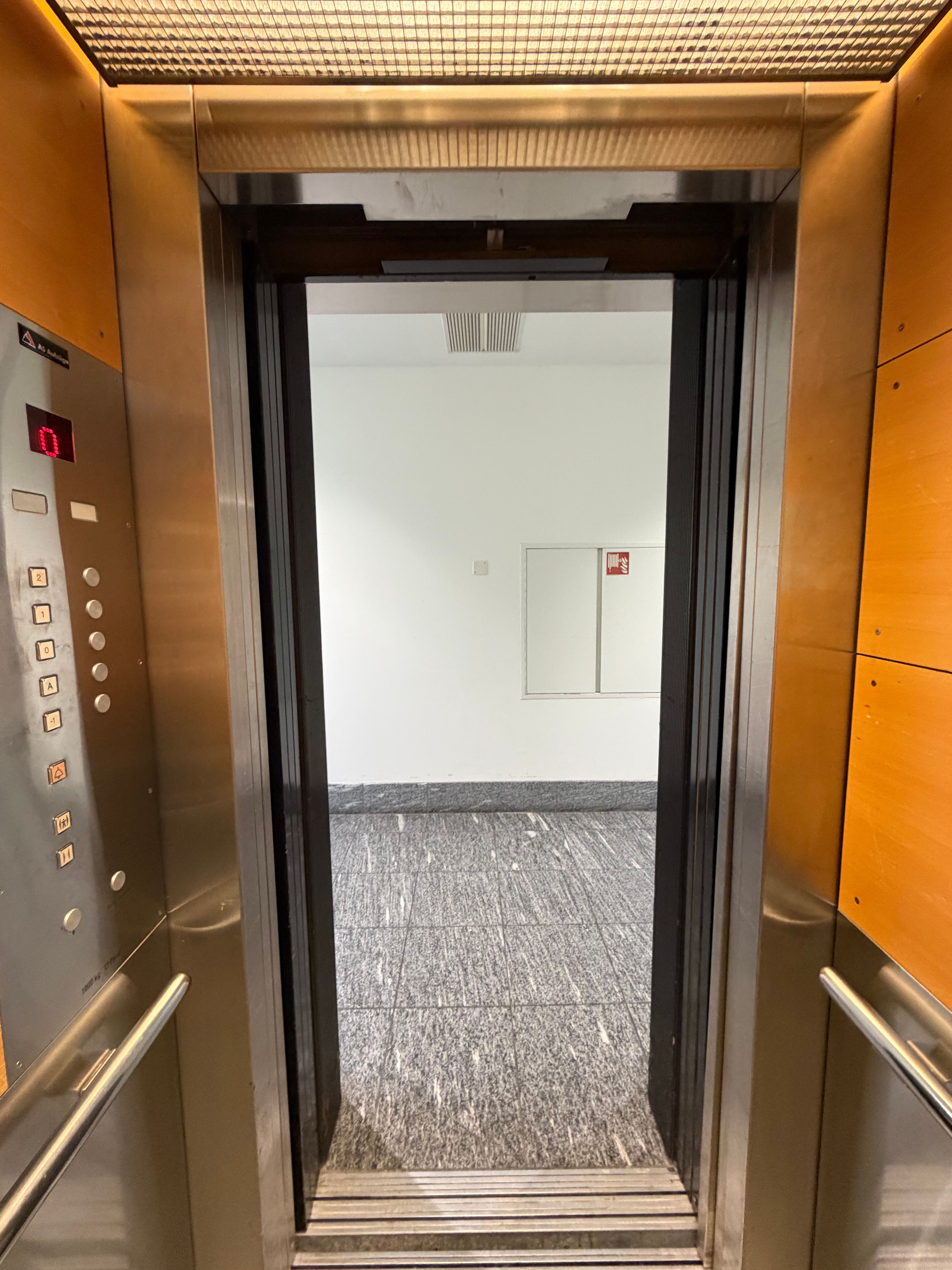 SOC_E (= EG): Blick aus dem Lift auf den Gang im EG (Stockwerk E). Keine Stufen vorhanden.