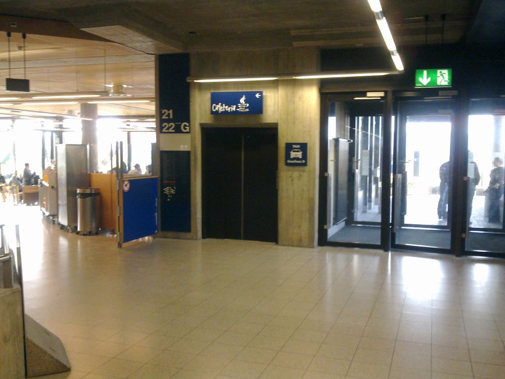 Y22-G, Balkon/Terrasse: Ausgang/Eingang aus dem Gebäude Y21/Y22 rechts im Bild. Links ist das Café Seerose. Die Drehtür findet man nach Durchlaufen des Cafés.