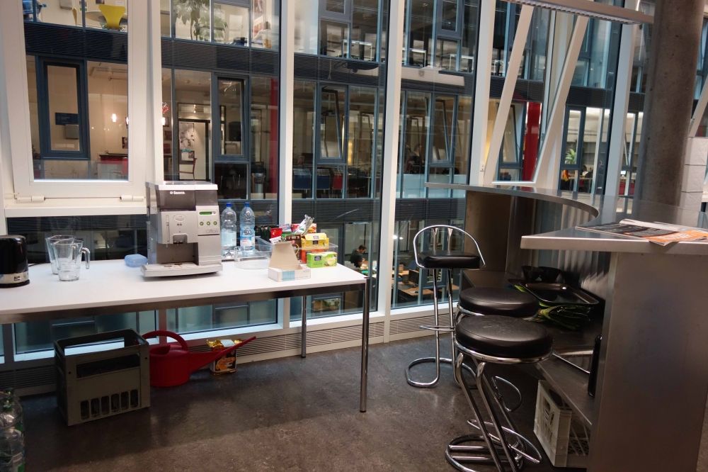 Aufenthaltsraum AND-2-11: Links der Tisch mit Wasserkocher und Kaffeemaschine, rechts die Bar mit Hockern.