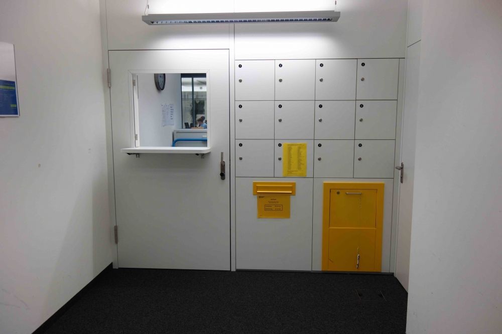 Postbüro AND-2-03: Der Schalter befindet sich bei der Tür links und hat eine Höhe von 116 cm. Der Briefkasten ist rechts davon auf 76 cm.