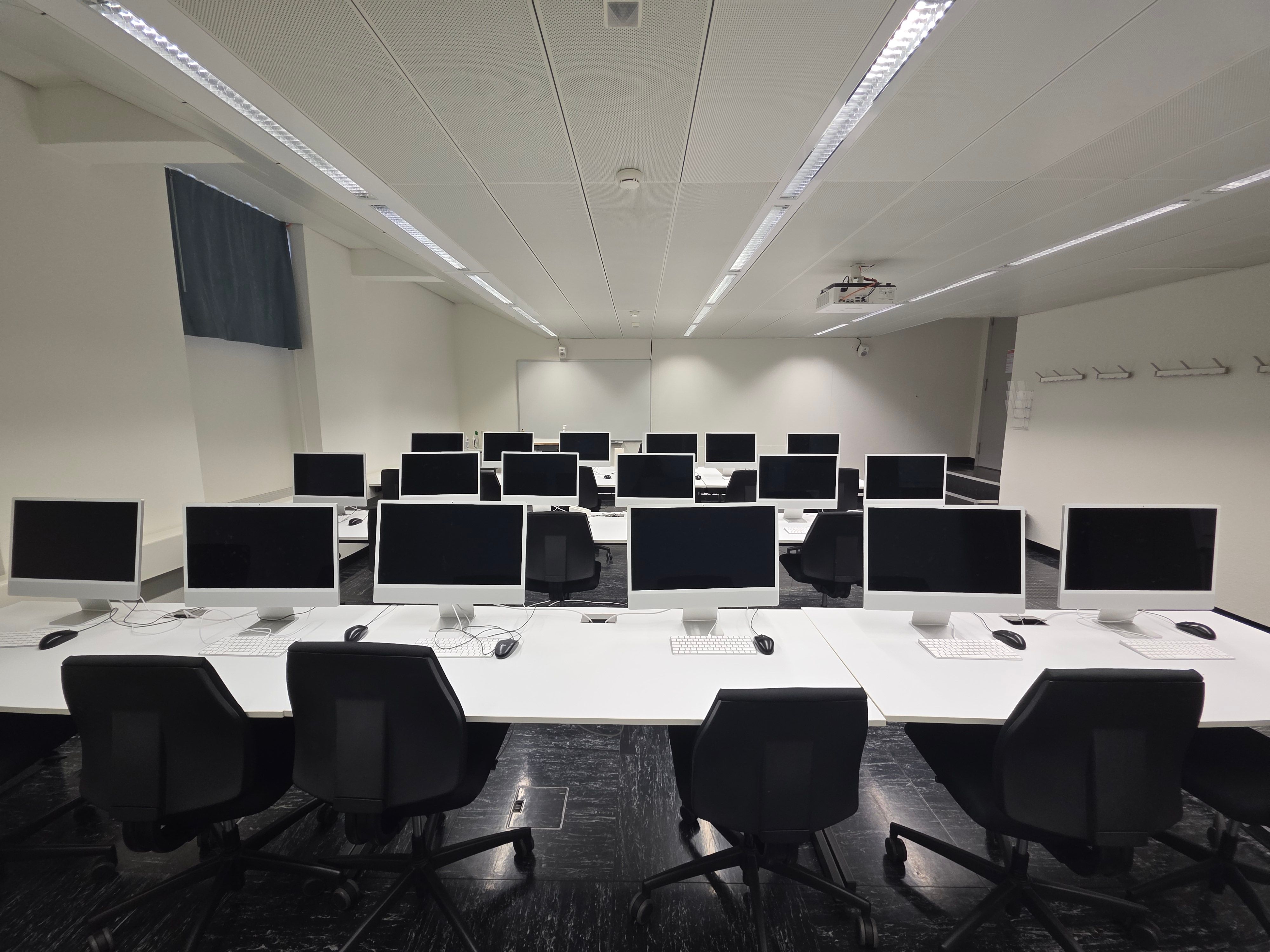 Computerkurs-Raum RAI-D-021: Ansicht der drei Tischreihen von hinten mit dem Blick zum Whiteboard.