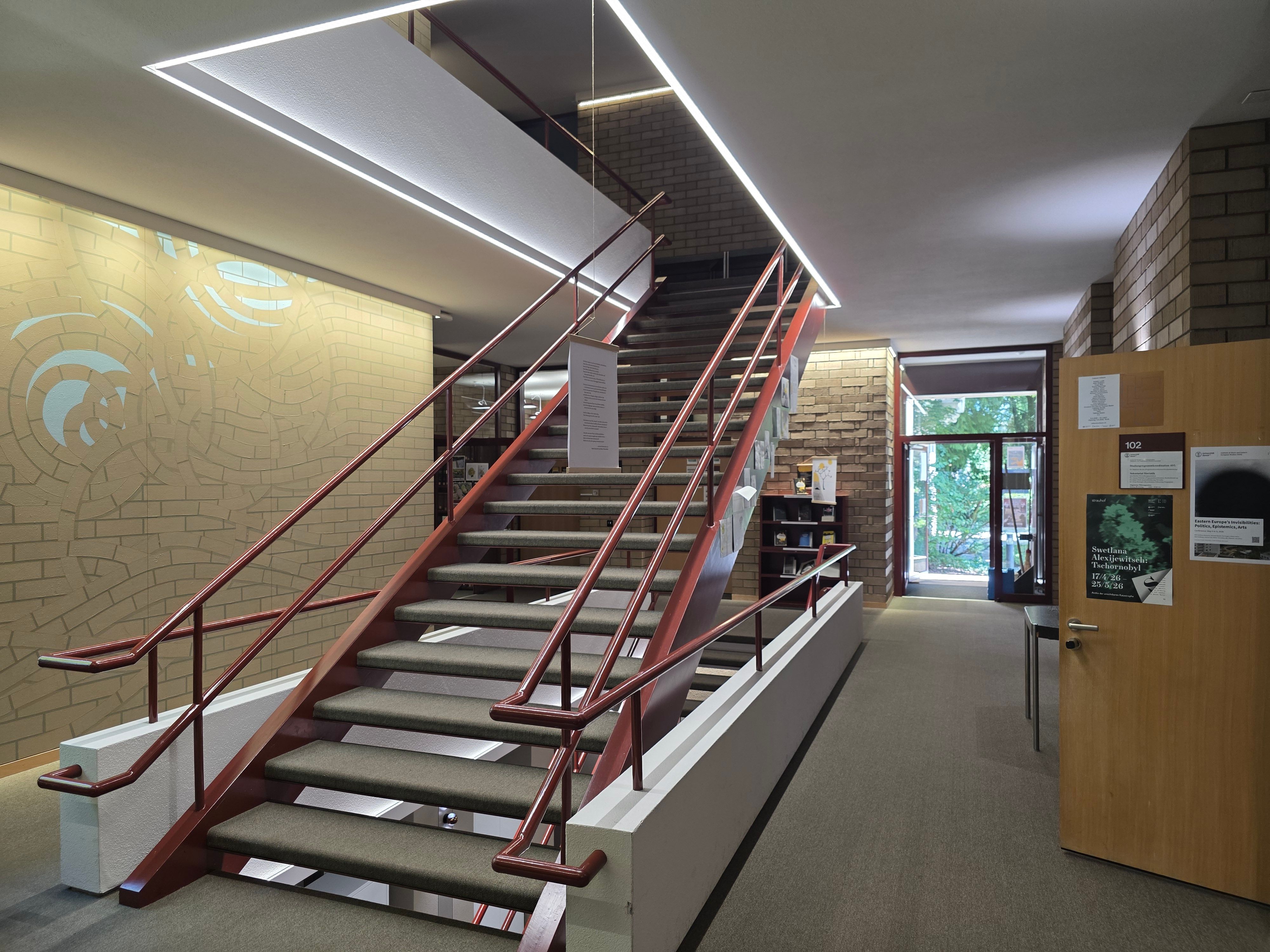 PLG Stockwerk B: Ansicht des Stockwerks. In der Mitte vom Bild sieht man die Treppe, die nach oben zum Stockwerk C führt. Im Hintergrund sieht man den zweiten Haupteingang vom Gebäude.