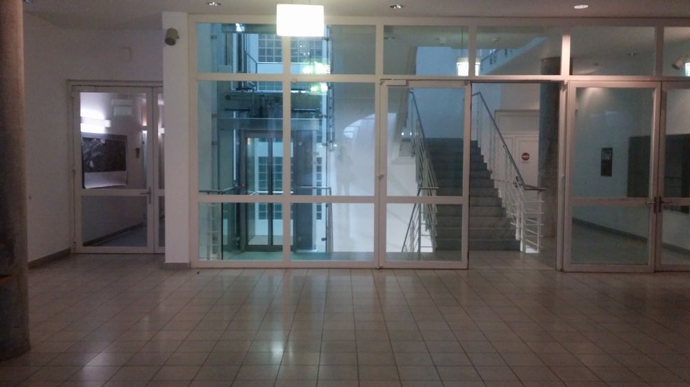 Y55, Stockwerk F: Eingangstüre zu Y55 auf der Ebene F, links hinter dem Glas ist der Lift zu sehen.