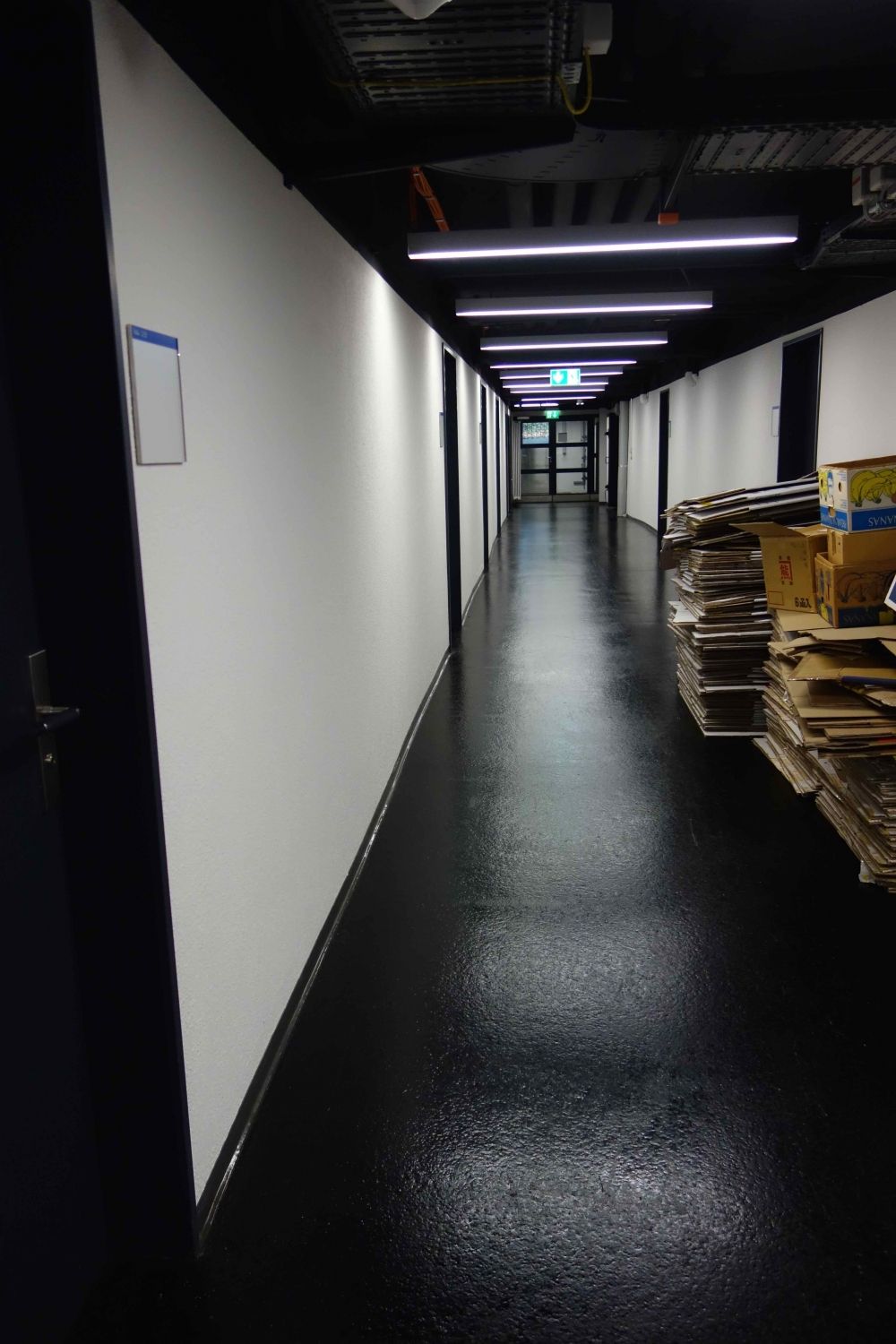Rollstuhl-WC RAA-D-10: Blick vom Lift aus Richtung Rollstuhl-WC. Das WC befindet sich am Ende des Gangs auf der linken Seite.