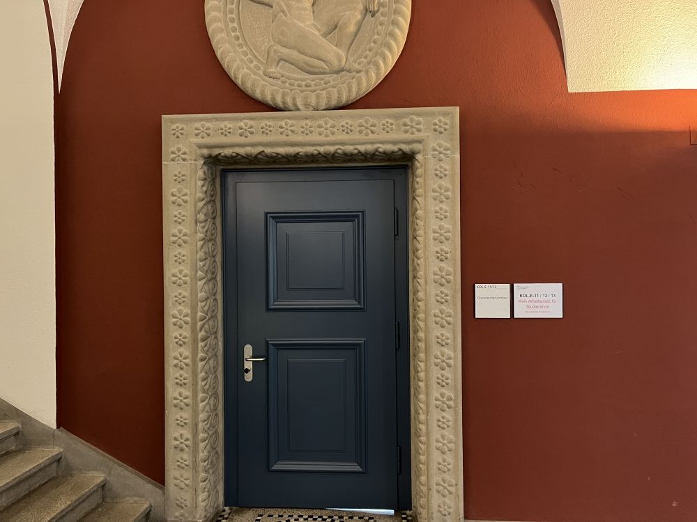 Aufenthaltsraum KOL-E-11: Der Eingang zum Dozierendenzimmer befindet sich bei den Seitentreppen und erfolgt über einen Vorraum (E-12). Siehe dazu auch das nächste Bild.
