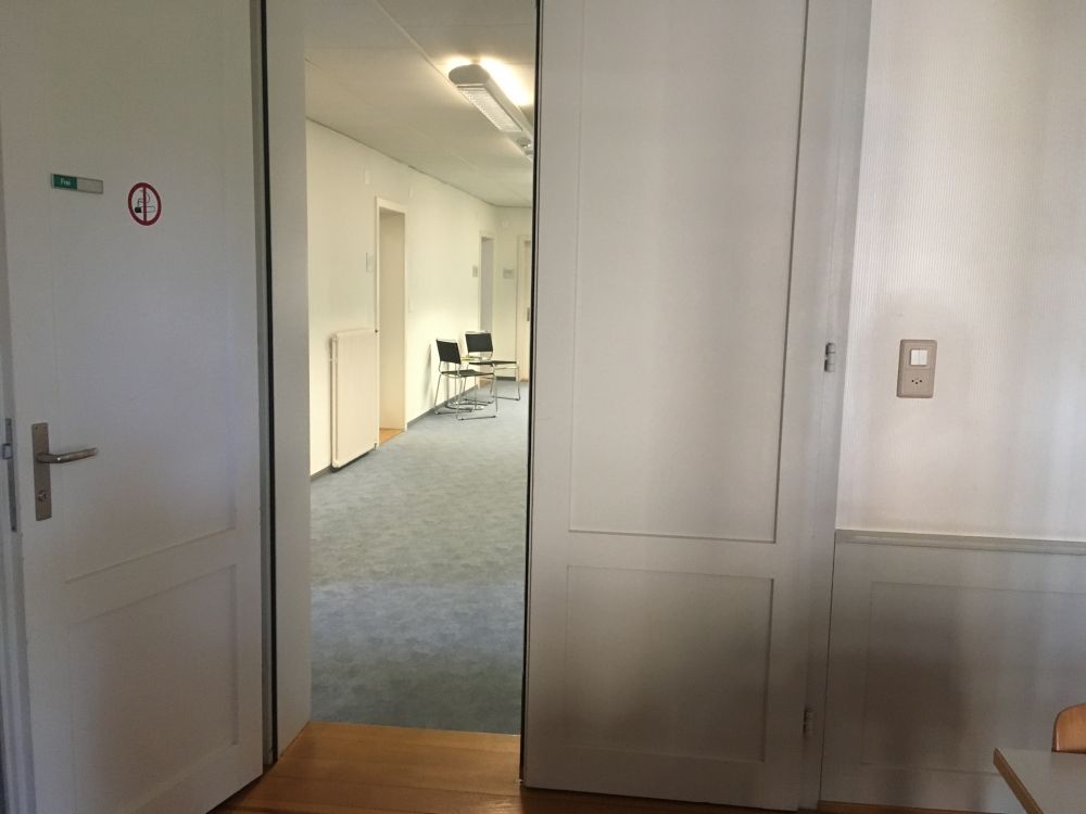 Sitzungsraum SOG-B-07: Eingang zum Sitzungszimmer mit Steckdose rechts.