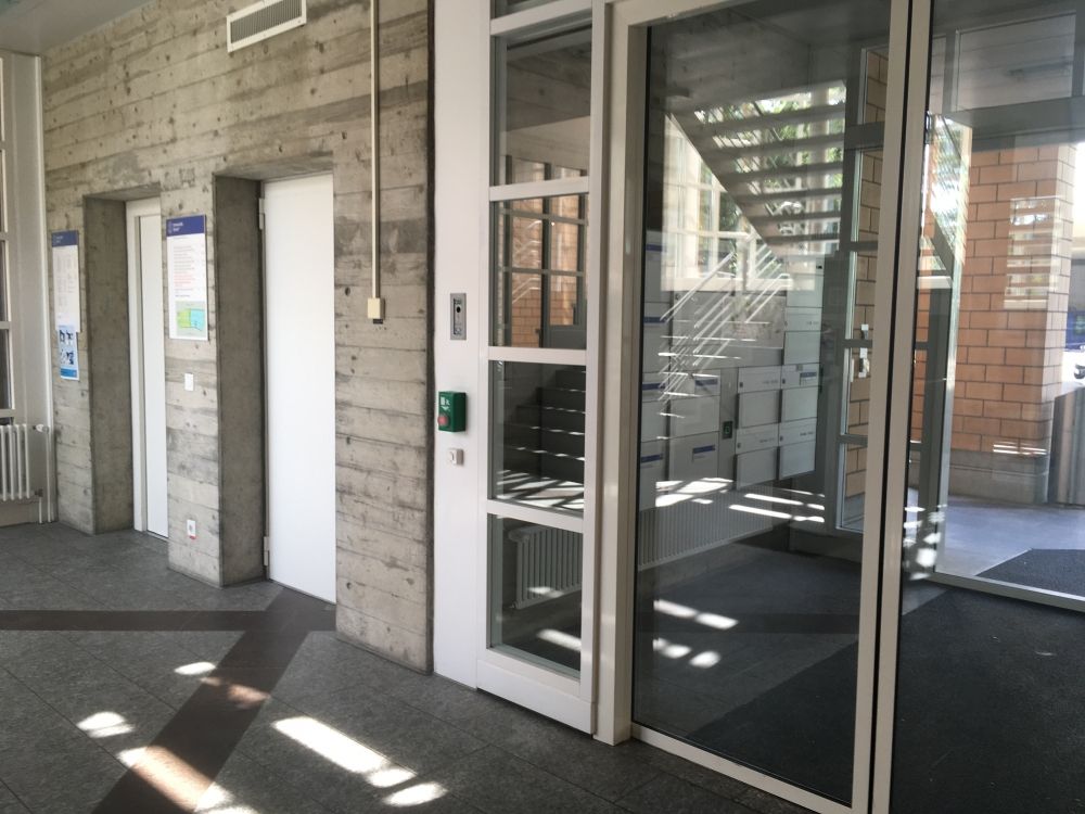 PLM, Lift: Links: Lift
Rechts: Haupteingang mit Schiebetür.