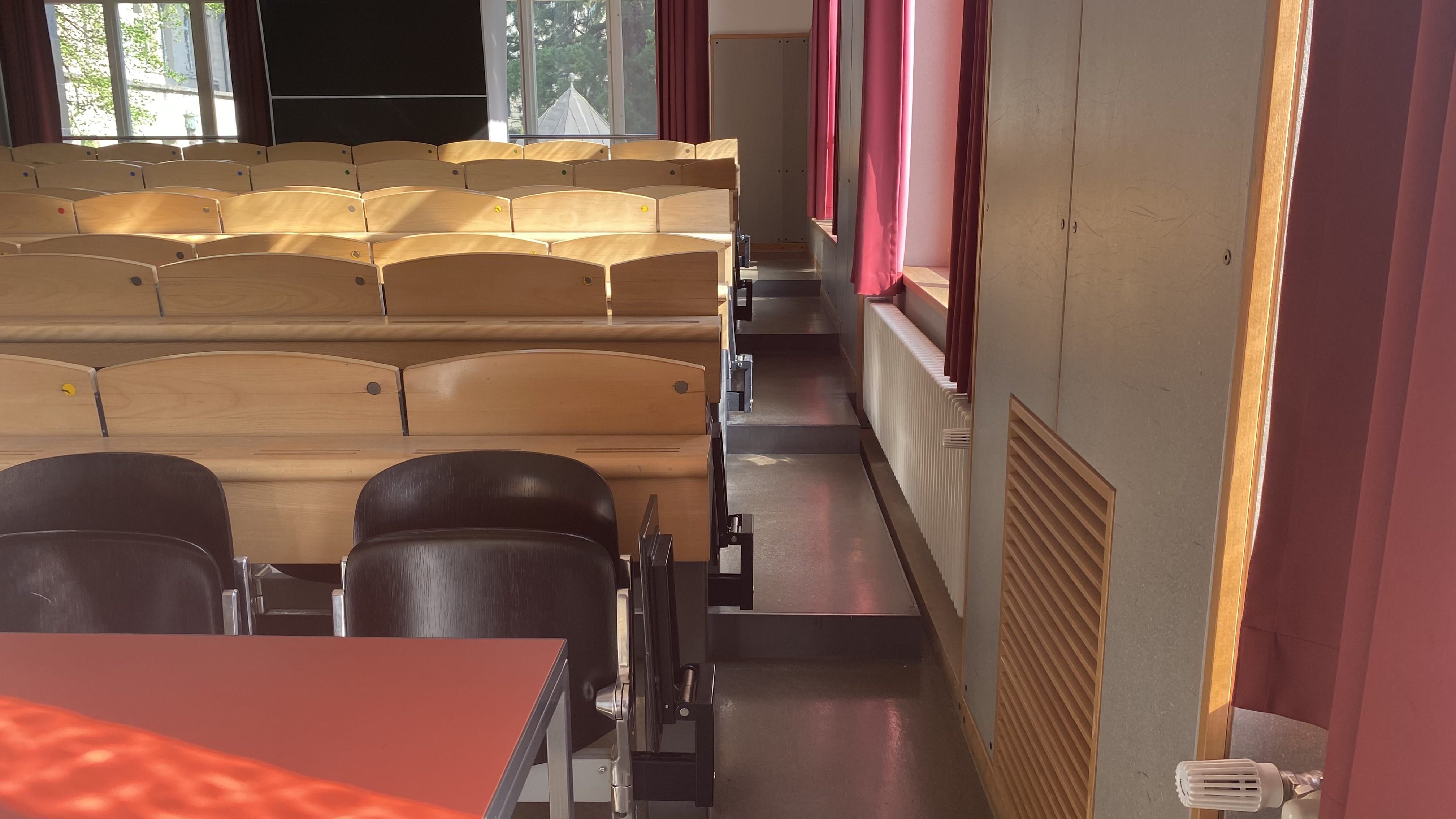 Hörsaal KOL-E-21: Ansicht auf den rechten, sehr schmalen Durchgang. Die Treppenstufen sind nicht mit Orientierungshilfen markiert.