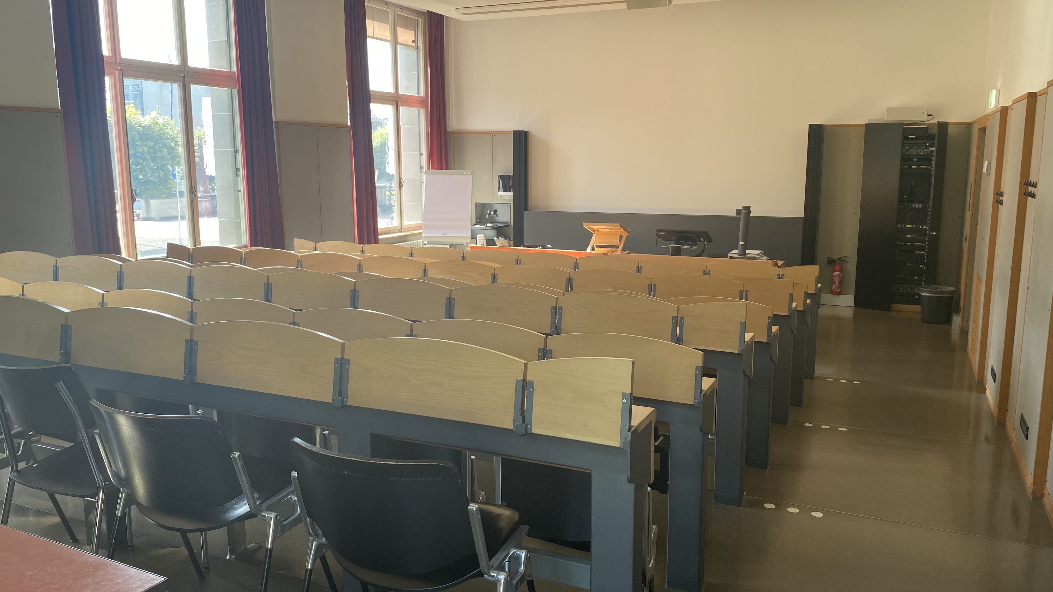 Hörsaal KOL-E-21: Ansicht zum Dozierendenpult hin. Die Treppenstufen rechts sind mit Orientierungshilfen markiert.