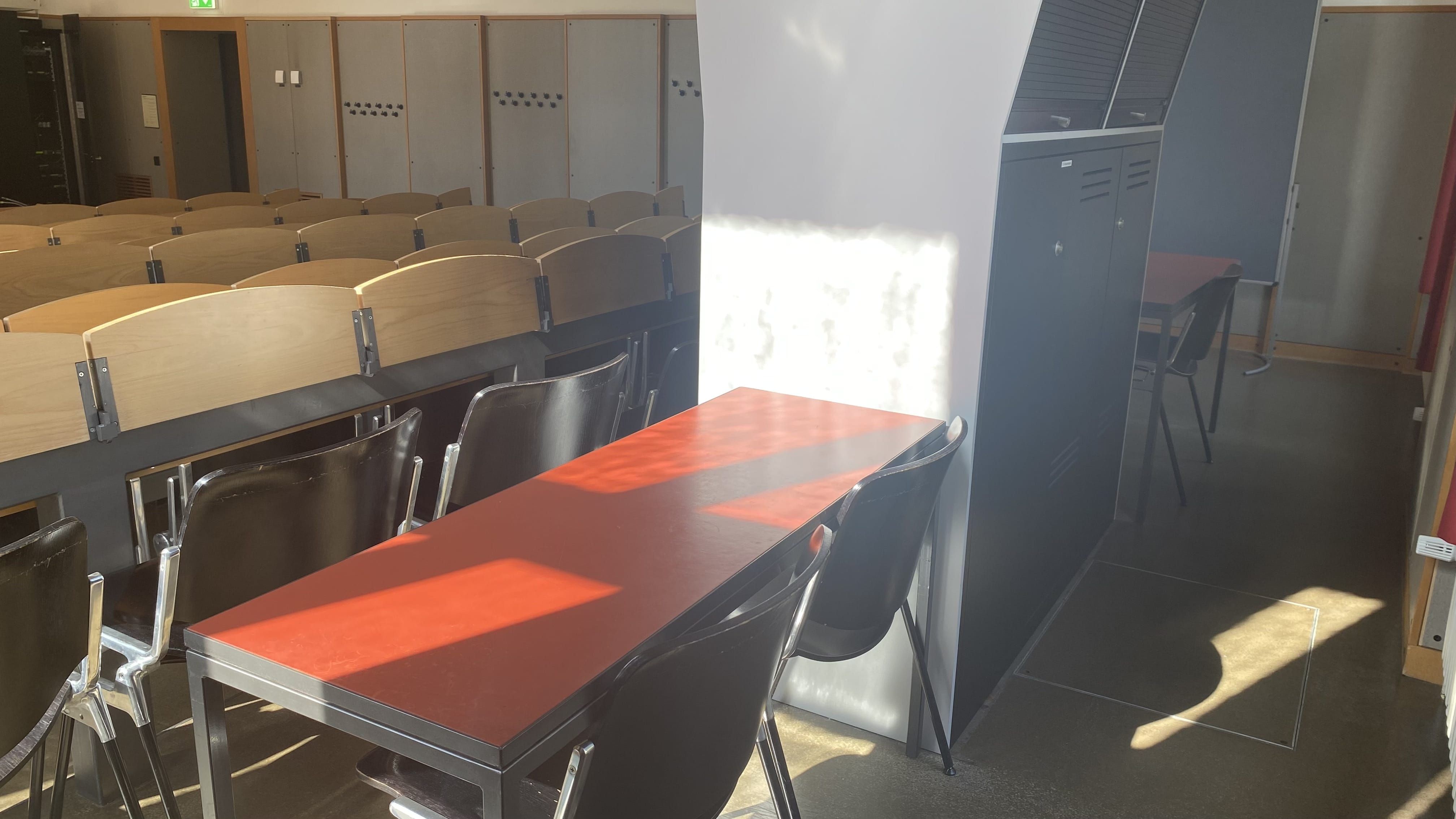Hörsaal KOL-E-21: Ansicht auf die hinterste Reihe mit Tischen ohne fixe Bestuhlung.