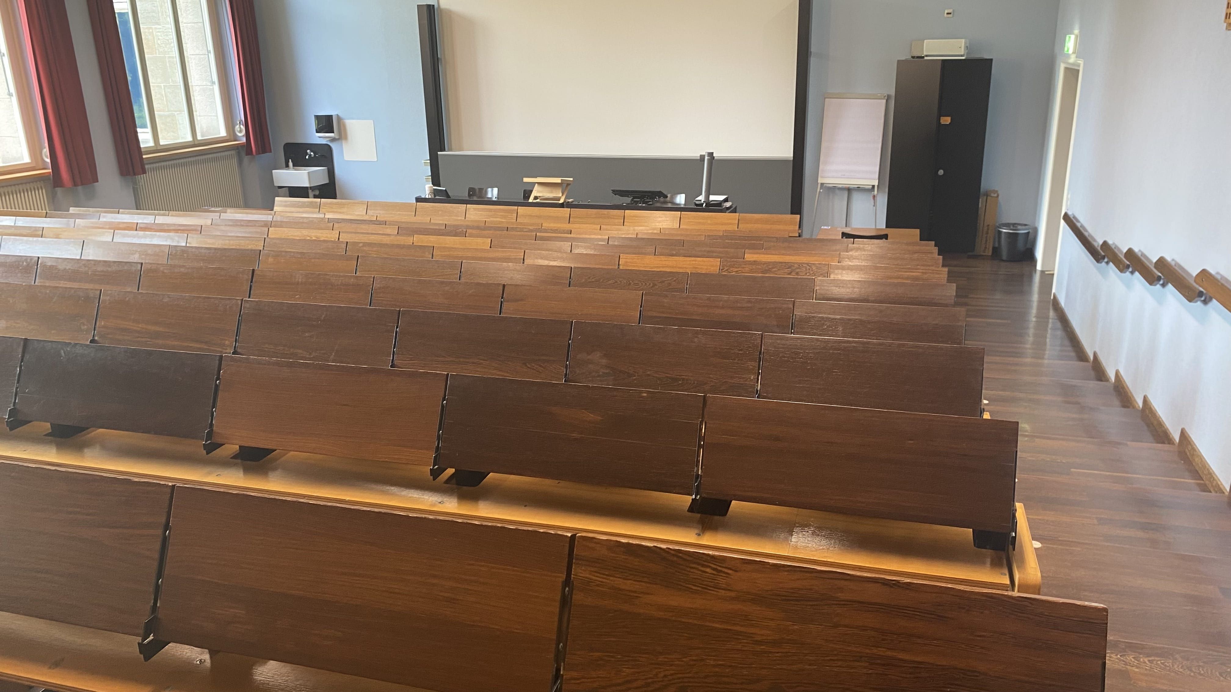 Hörsaal KOL-F-118: Ansicht zum Dozierendenpult hin. Die Eingangstüre befindet sich rechts im Bild.