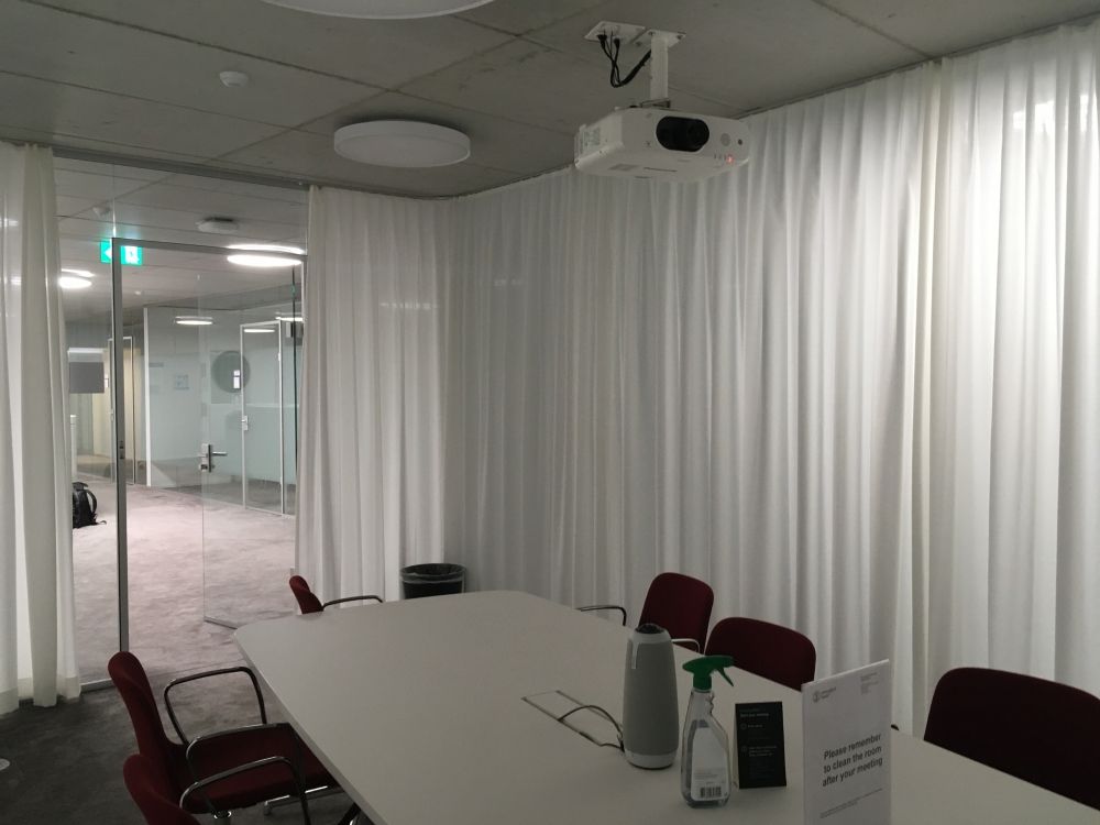 Sitzungsraum PLR-F-111: Innenansicht Sitzungszimmer mit Rücken zur Leinwand gegenüber der Türe.