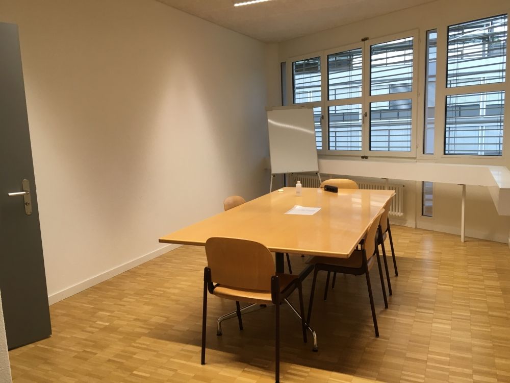 Sitzungsraum PLM-H-309: Sitzungsraum mit Tür auf der linken Seite.