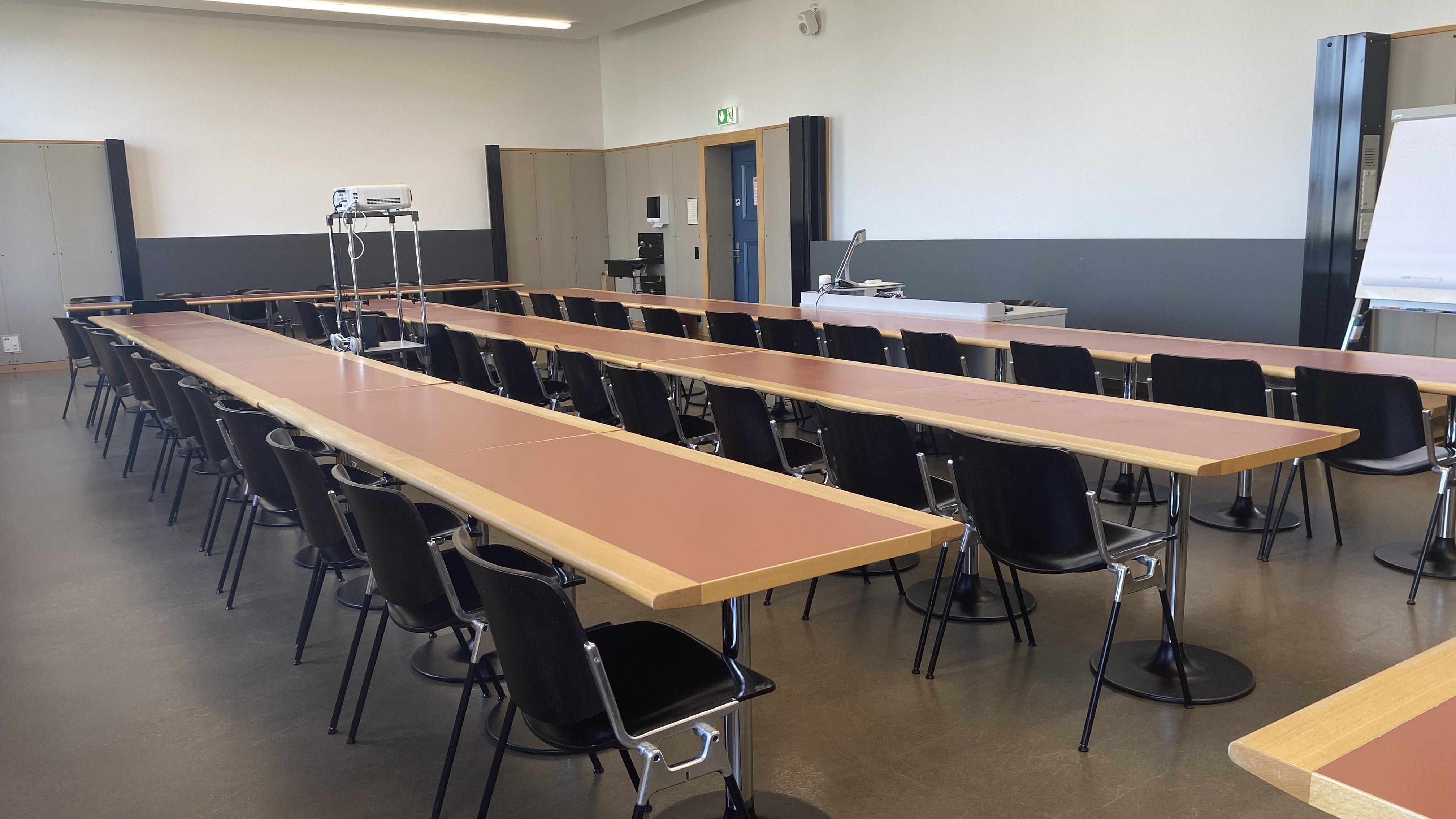 Seminarraum KOL-G-212: Ansicht auf den Raum. Die erste von zwei Eingangstüren befindet sich in der Mitte des Bildes.