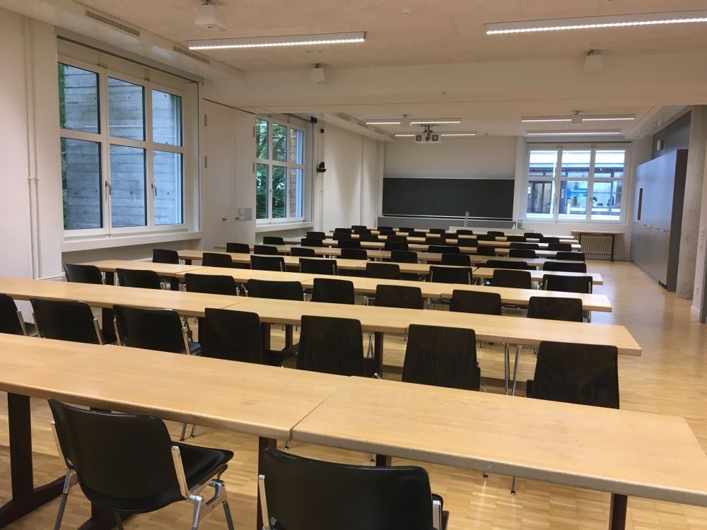 Seminarraum PLM-F-103: Seminarraum mit Sicht auf Leinwand.