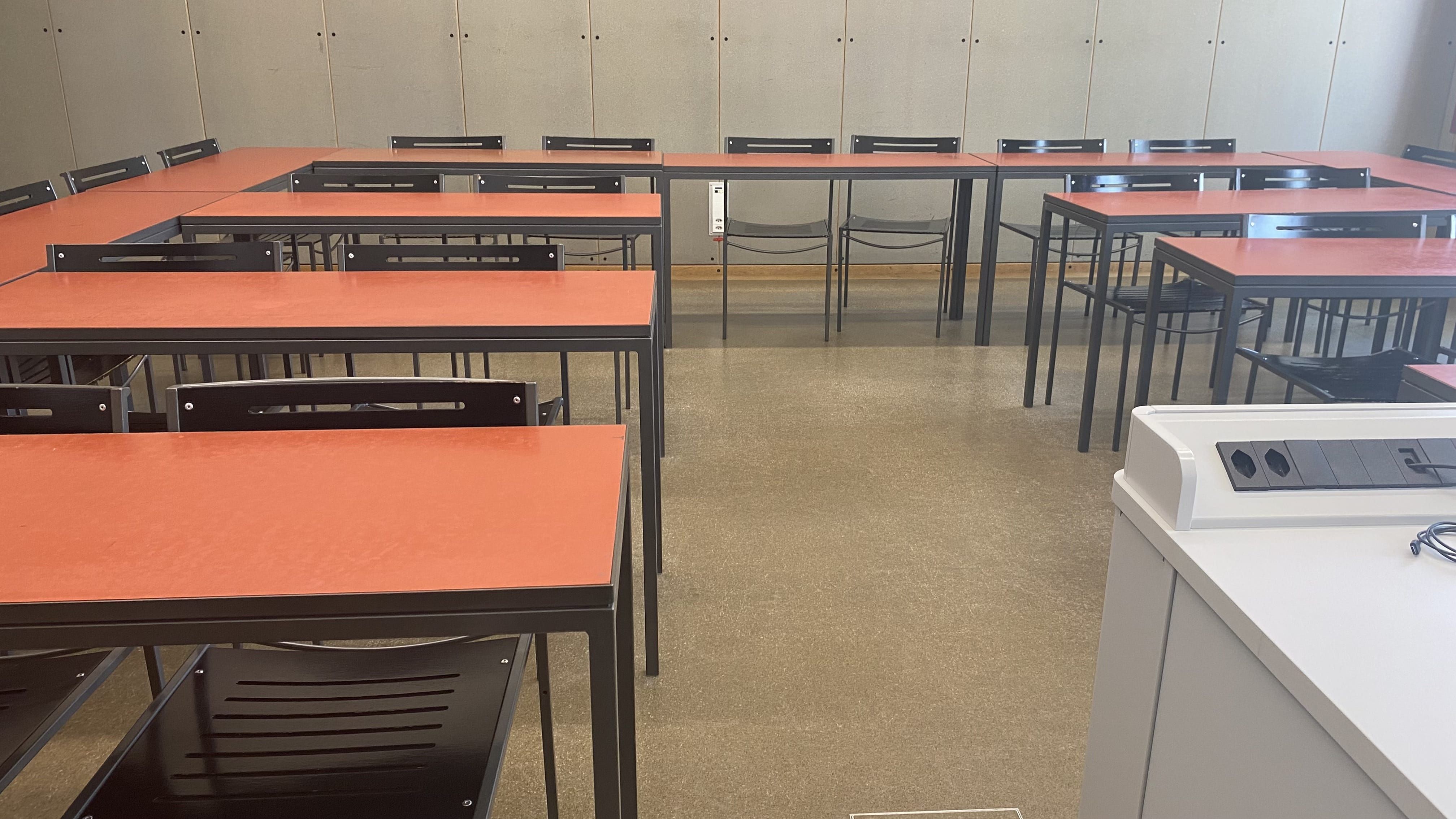 Seminarraum KOL-G-220: Ansicht auf die Sitzreihen vom Dozierendenpult aus.