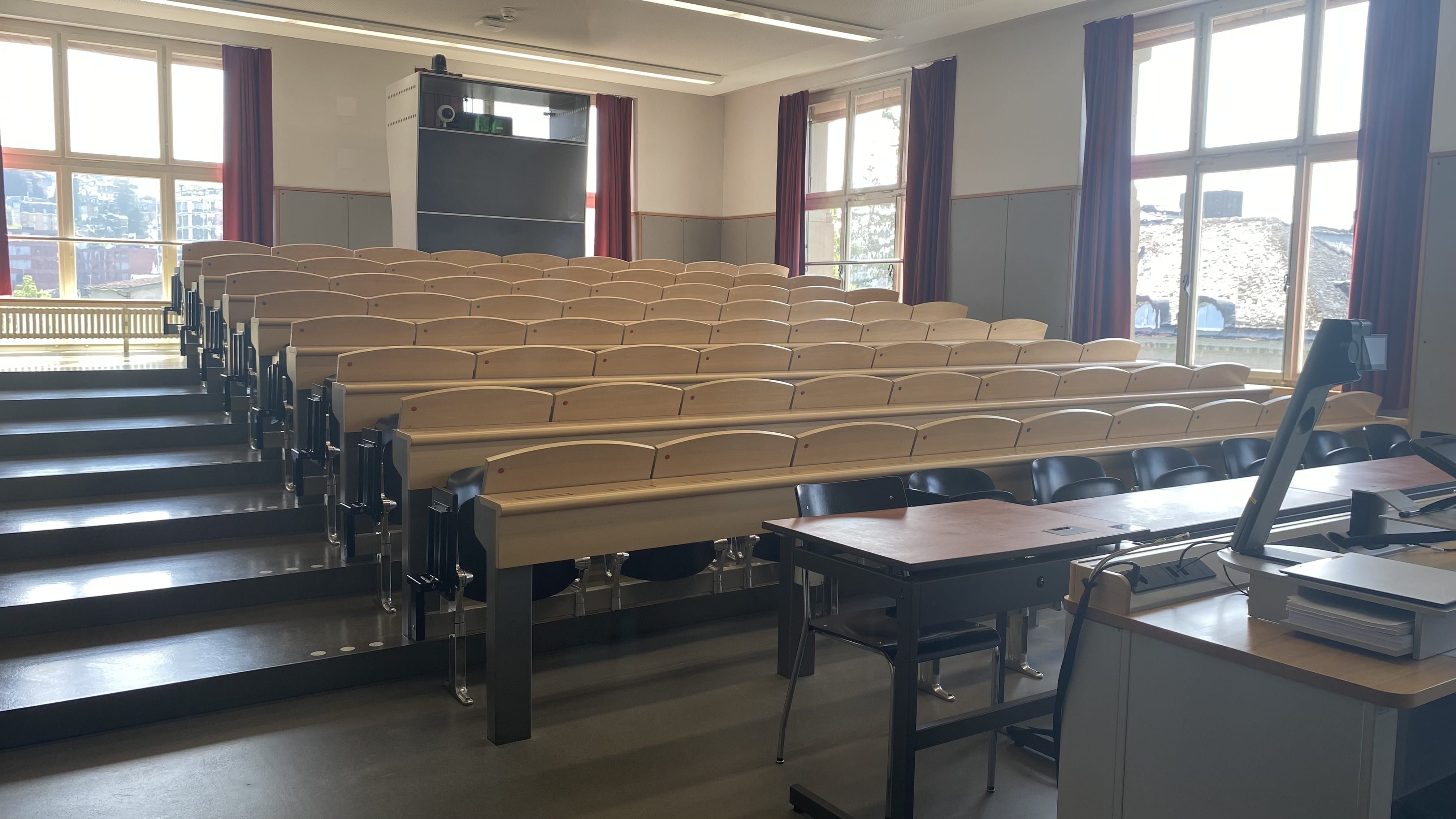 Hörsaal KOL-G-204: Ansicht auf den Raum von der Eingangstür aus. Die breiten Stufen links sind mit Orientierungshilfen markiert.