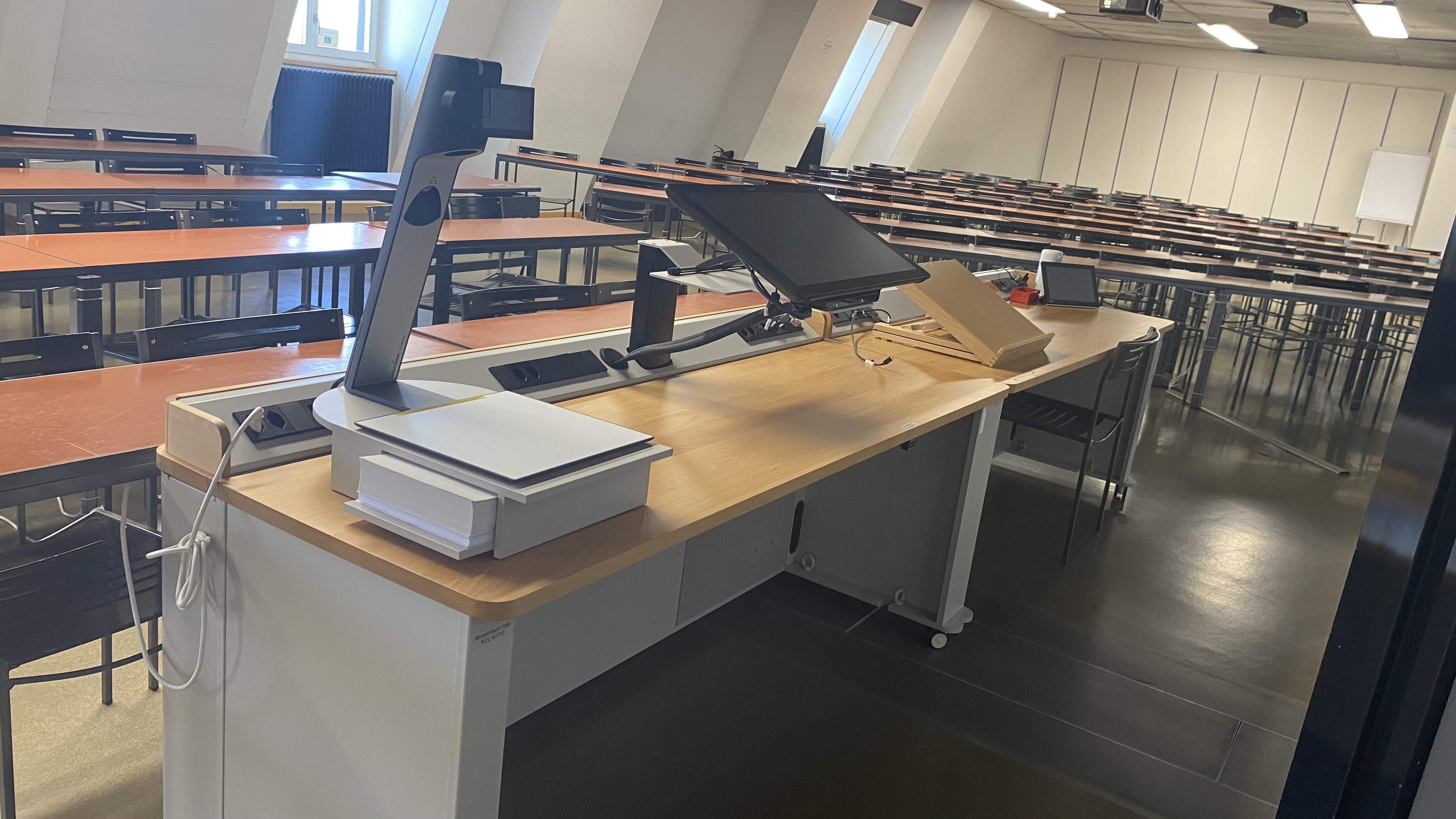 Hörsaal KOL-H-312a: Ansicht auf das Dozierendenpult.
