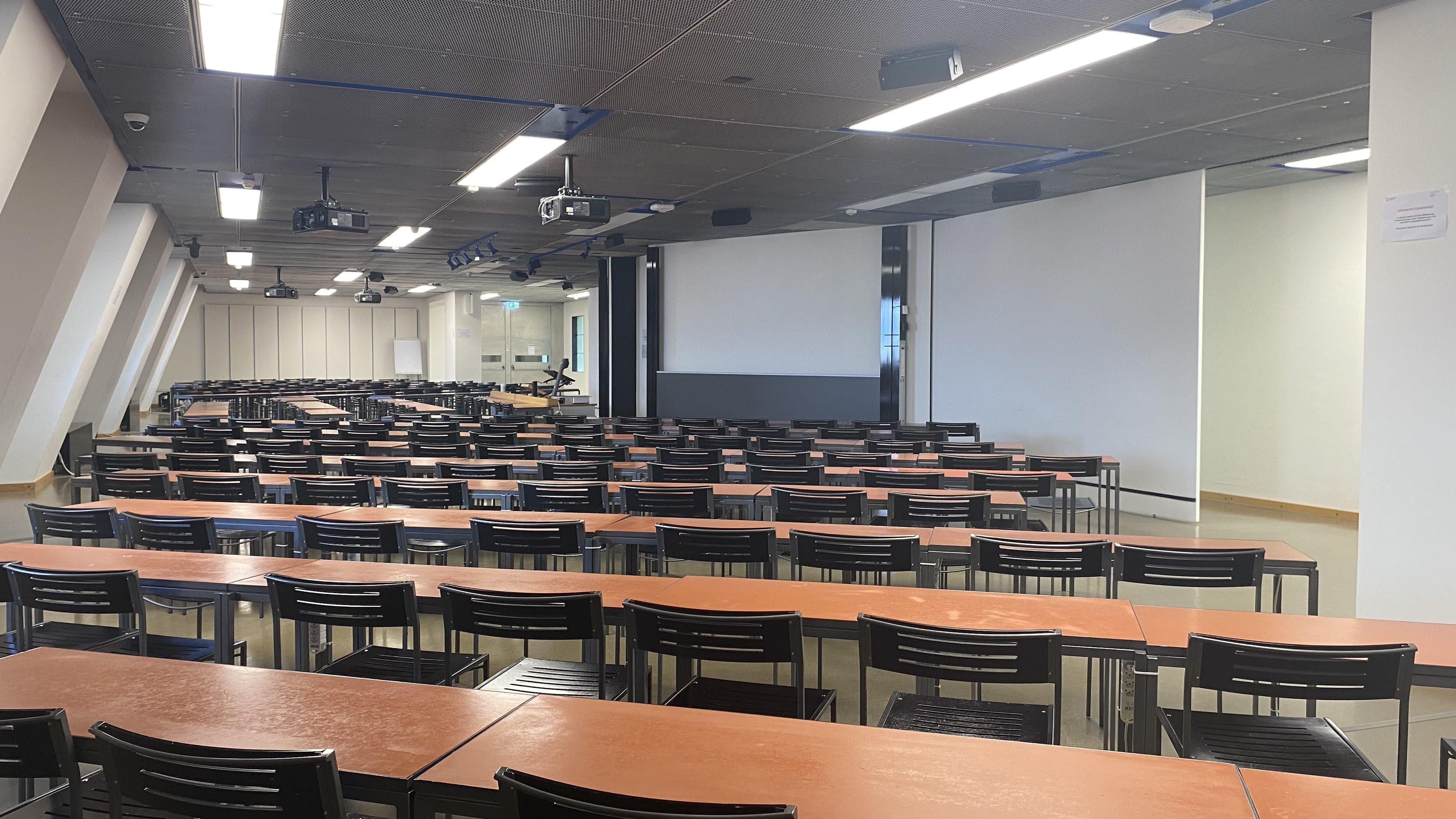 Hörsaal KOL-H-312a: Ansicht auf den Raum zur Leinwand hin.