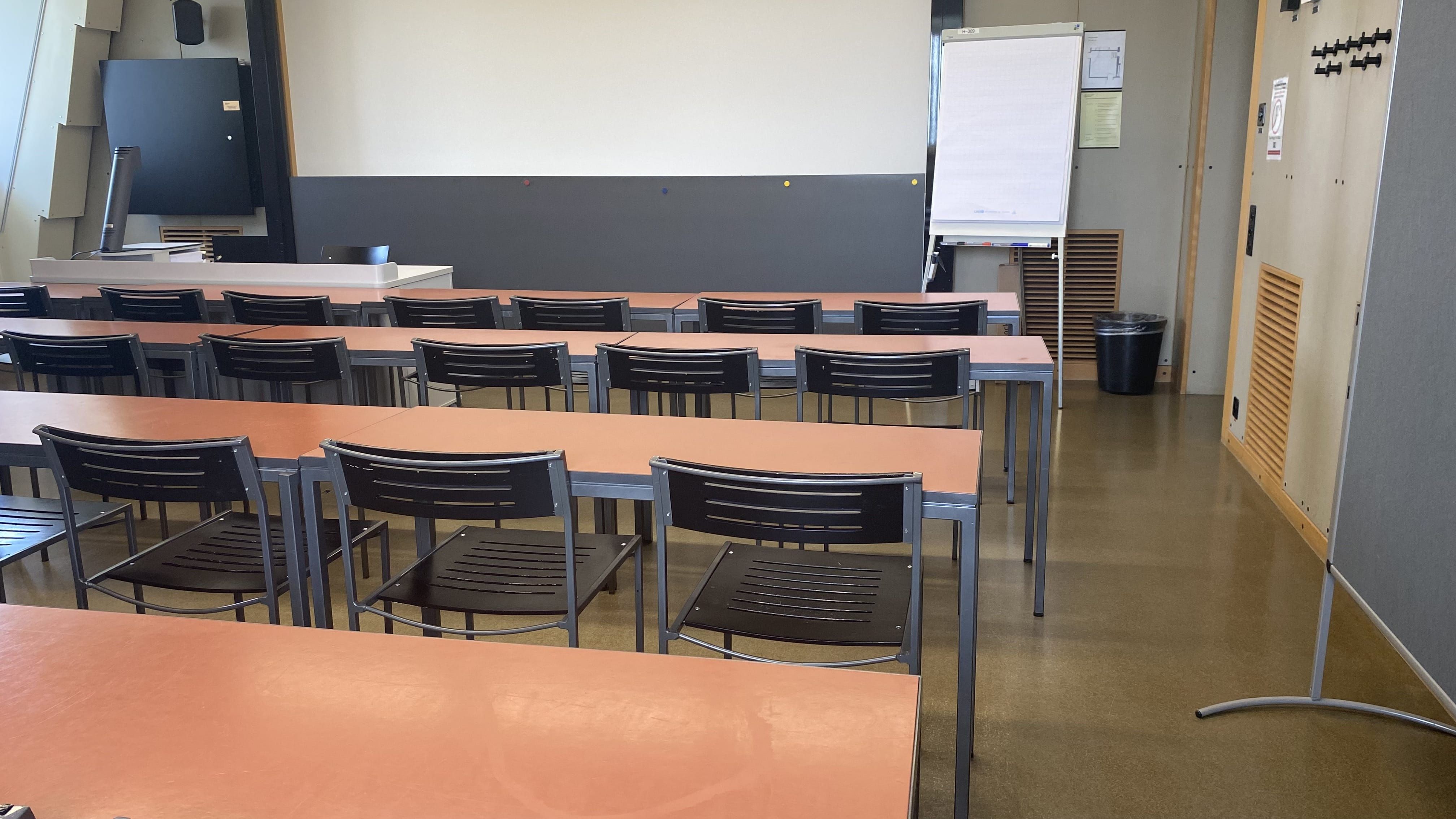 Seminarraum KOL-H-309: Ansicht zum Dozierendenpult hin. Die Eingangstür befindet sich rechts im Bild.