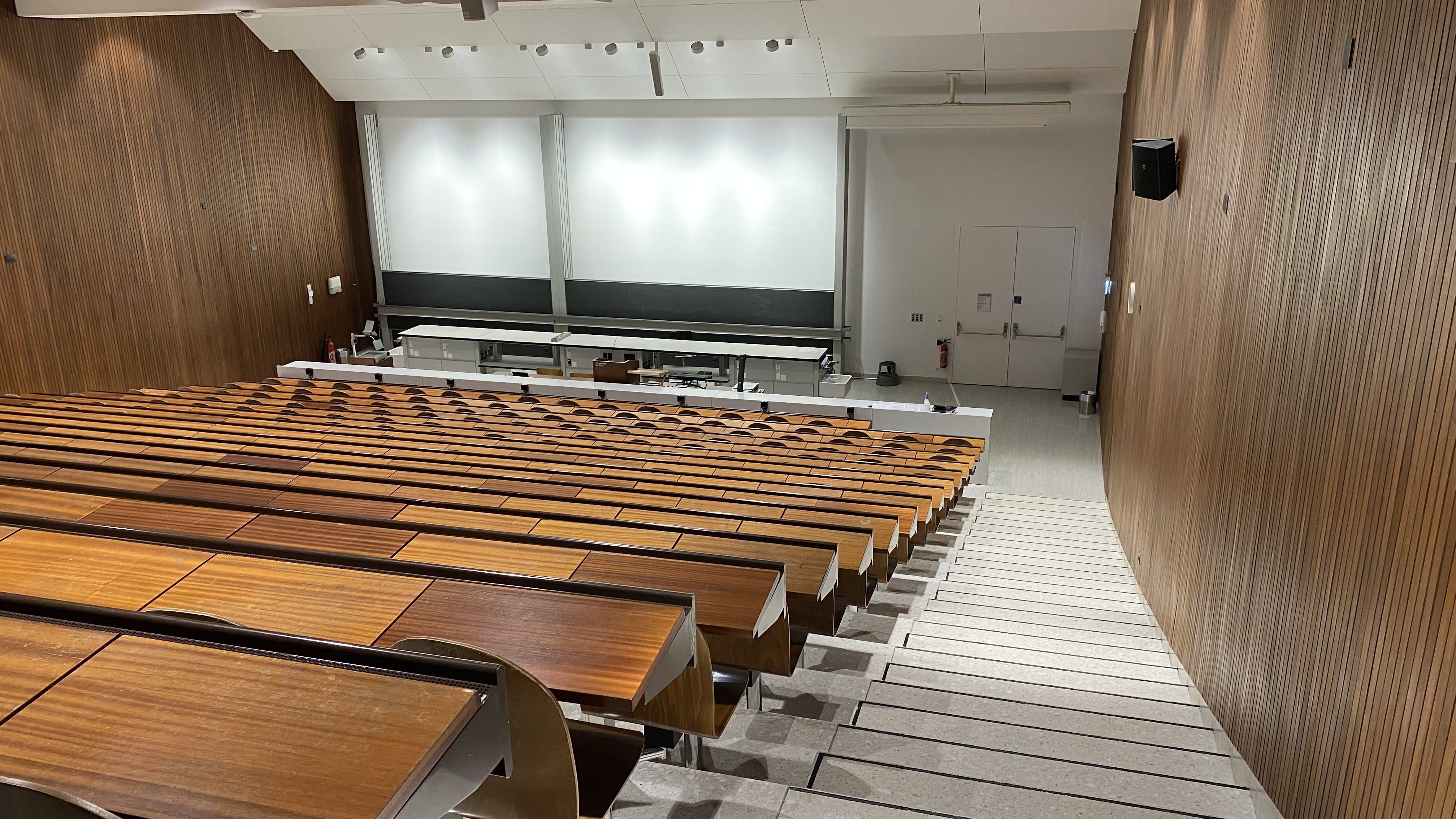 Hörsaal Y15-G-60: Ansicht auf den Raum von der rechten Eingangstür aus. Der Notausgang befindet sich rechts unten im Raum.