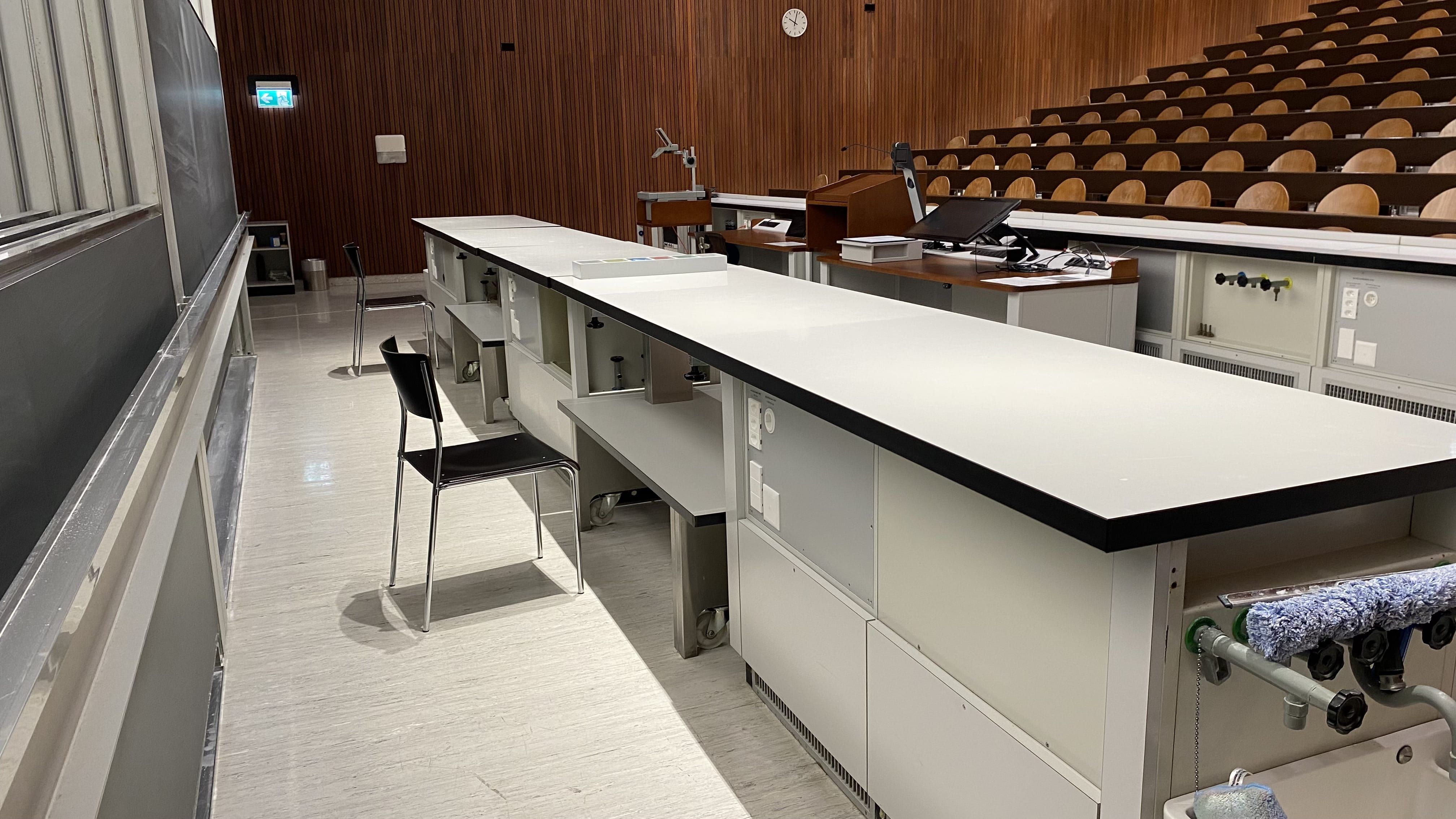 Hörsaal Y15-G-40: Ansicht auf die Tische hinter dem Dozierendenpult.