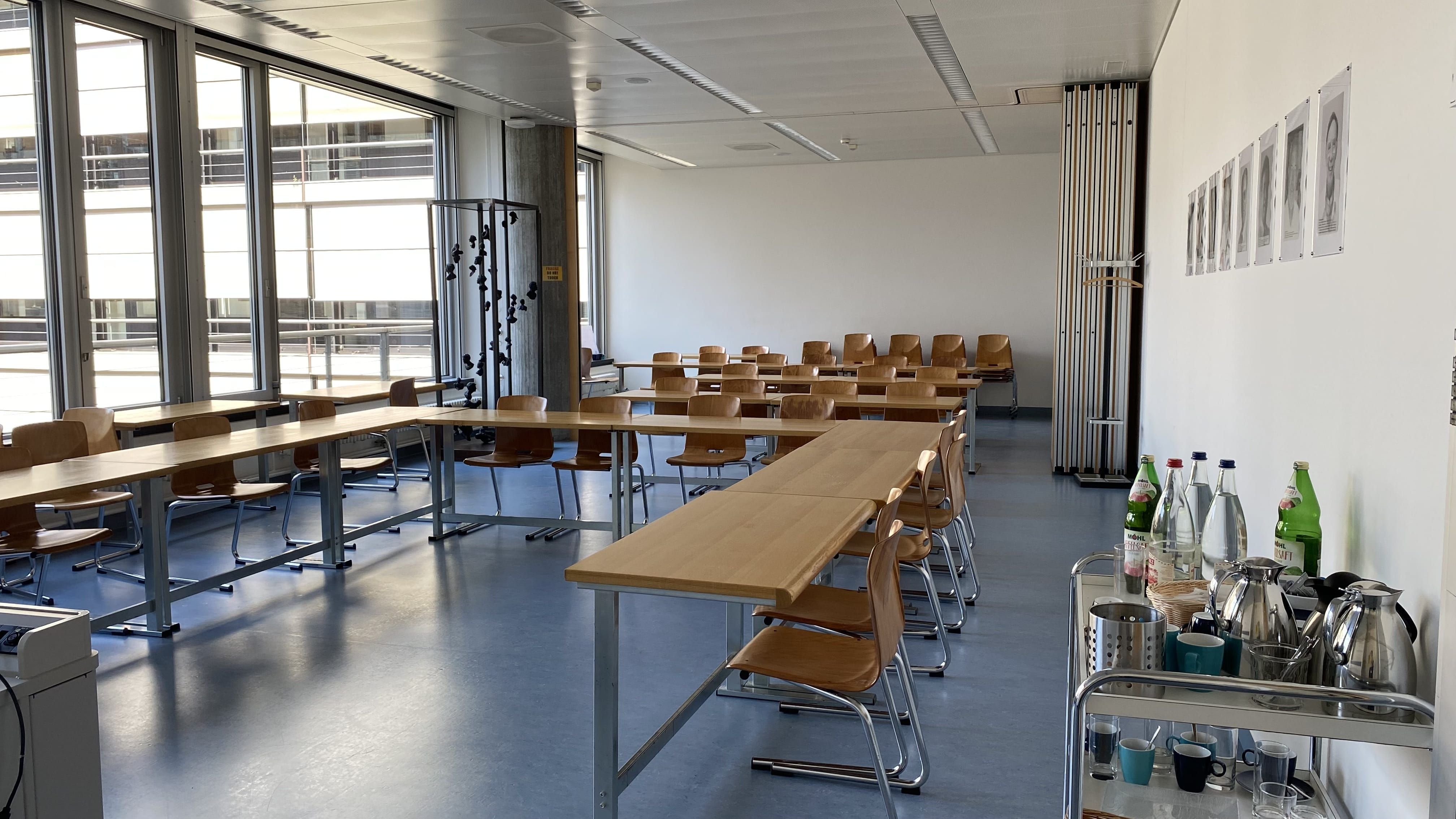 Seminarraum Y55-H-12: Ansicht auf den Raum von der Eingangstür beim Dozierendenpult aus.