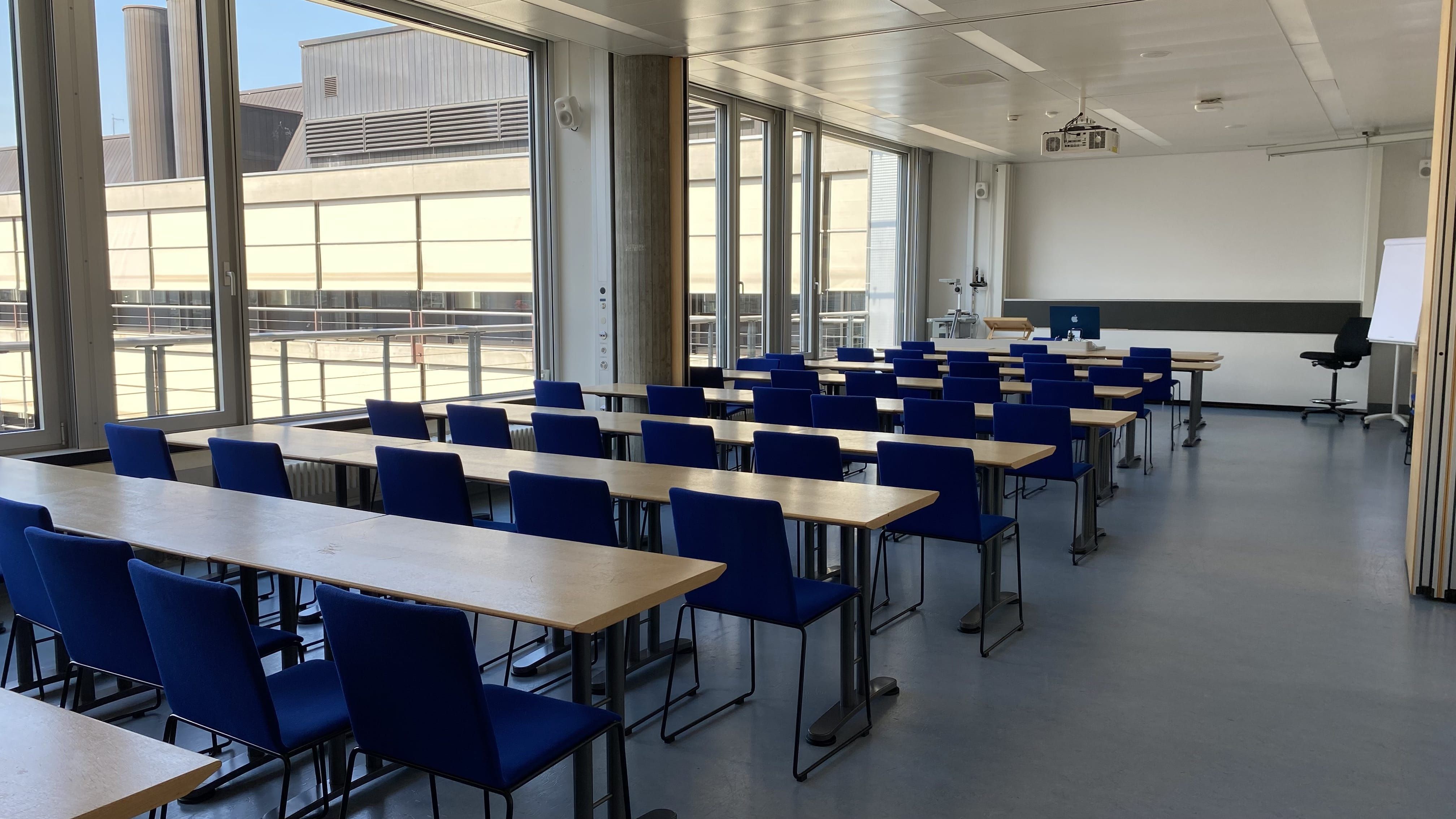 Seminarraum Y55-L-08: Ansicht auf den Raum zum Dozierendenpult hin. Der Raum L-08 und L-06 sind verbunden und können über eine Trennwand (rechts im Bild) voneinander abgetrennt werden.