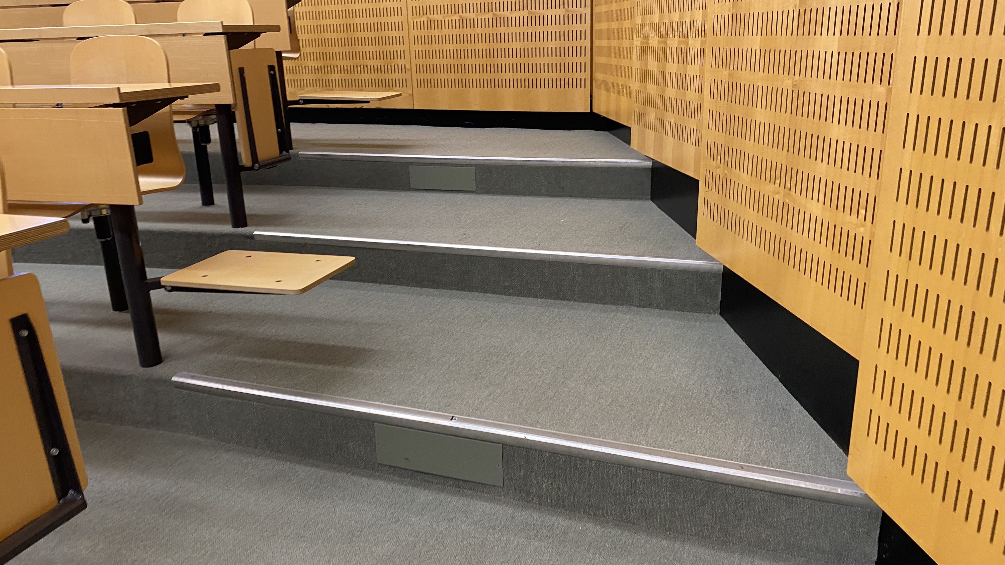 Hörsaal Y17-M-05: Ansicht auf die Stufen, die links und rechts im Raum zu den hinteren Sitzreihen führen.