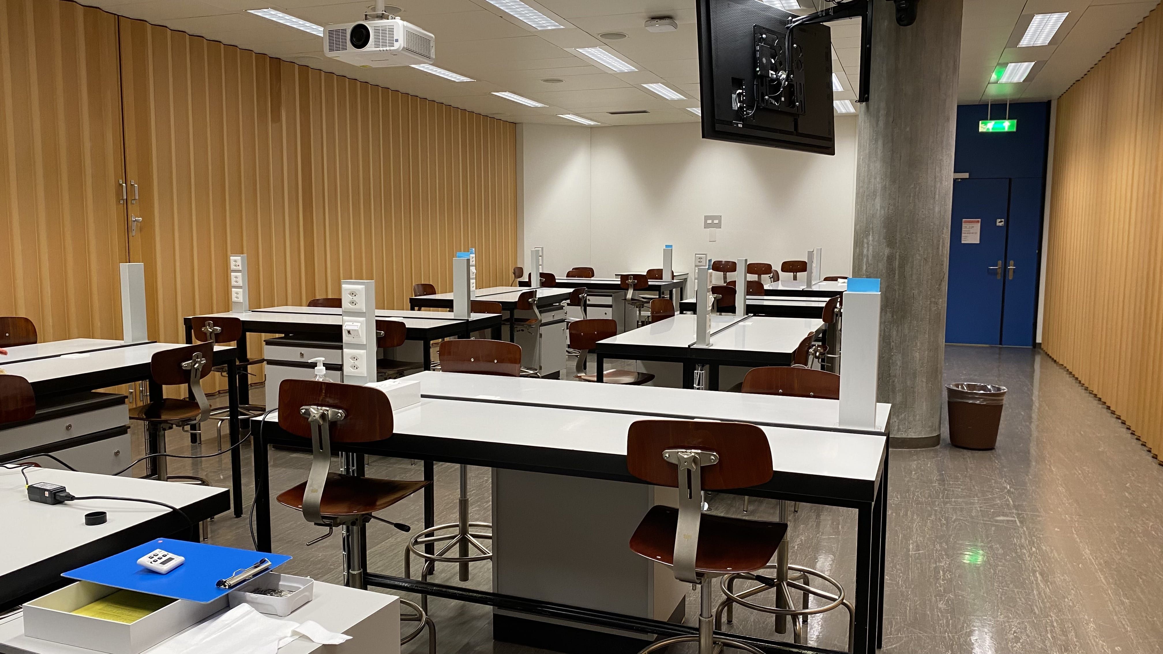 Hörsaal Y44-G-09: Ansicht auf den Raum vom hintersten Tisch aus. Die Eingangstür befindet sich rechts im Bild.