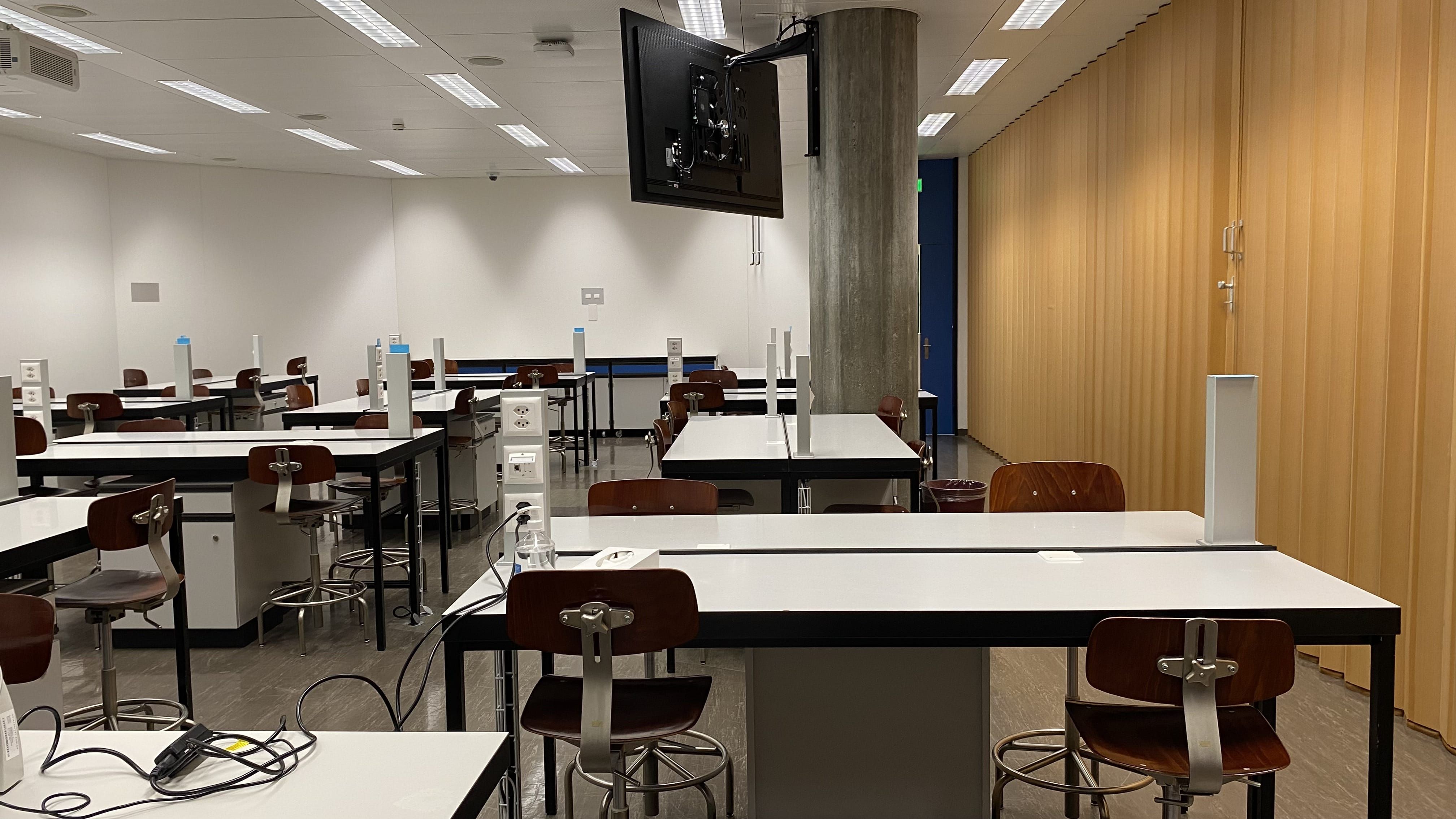 Hörsaal Y44-G-13: Ansicht auf den Raum vom Dozierendenpult aus. Die Eingangstür befindet sich hinter der grauen Säule rechts.