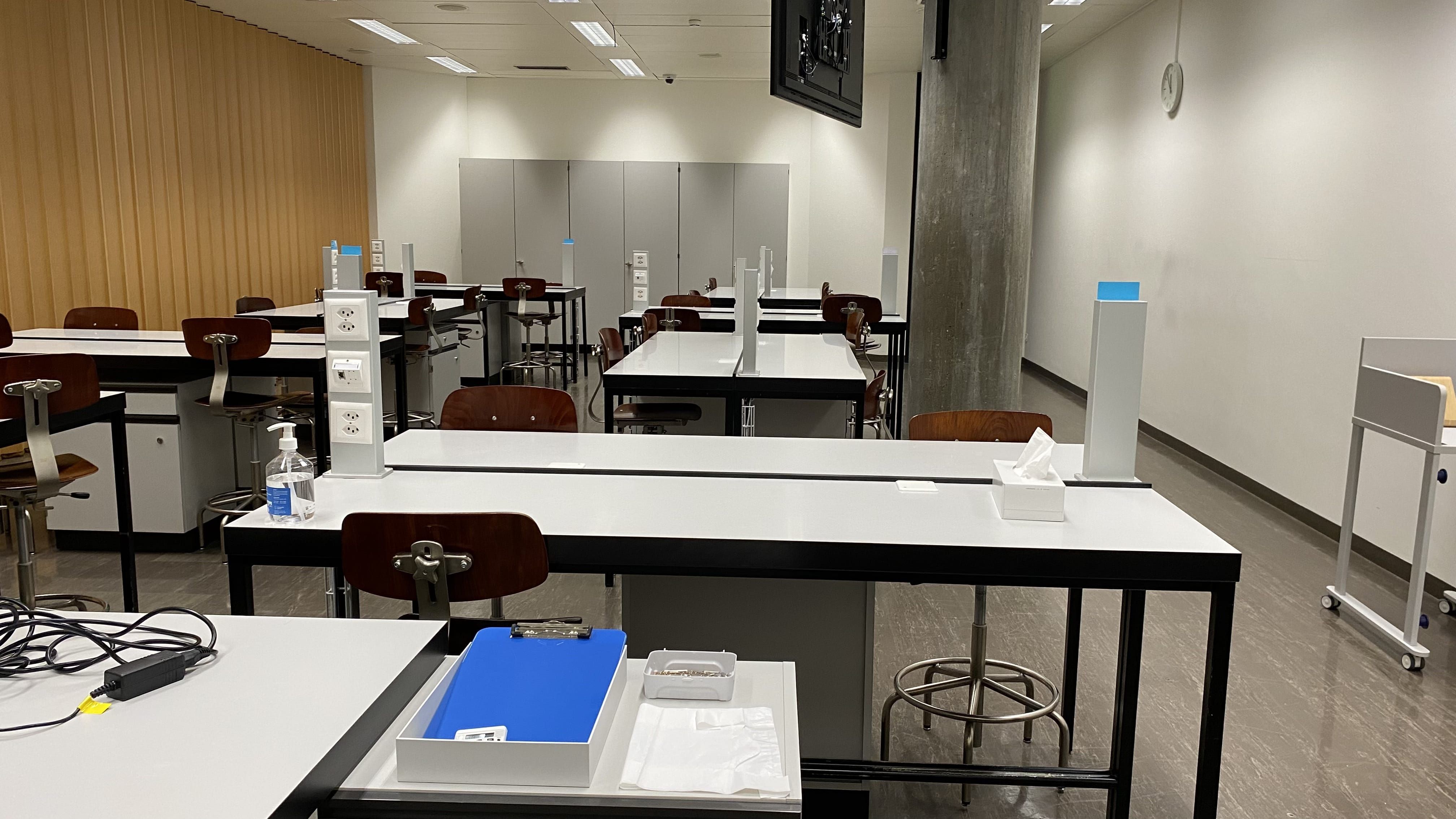 Hörsaal Y44-G-05: Ansicht auf den Raum vom hintersten Tisch aus. Die Eingangstür befindet sich am Ende des Raumes hinter der grauen Säule.