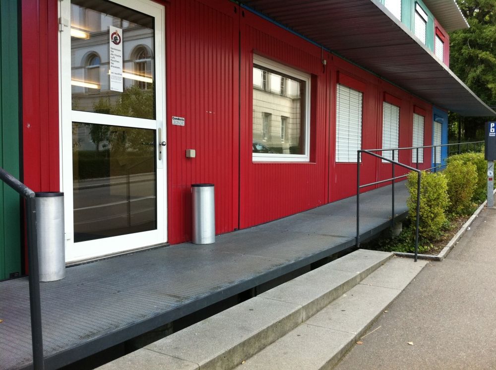 Gebäude SOE: Eingangstüre, rechts die Rampe für Rollstuhlfahrende.