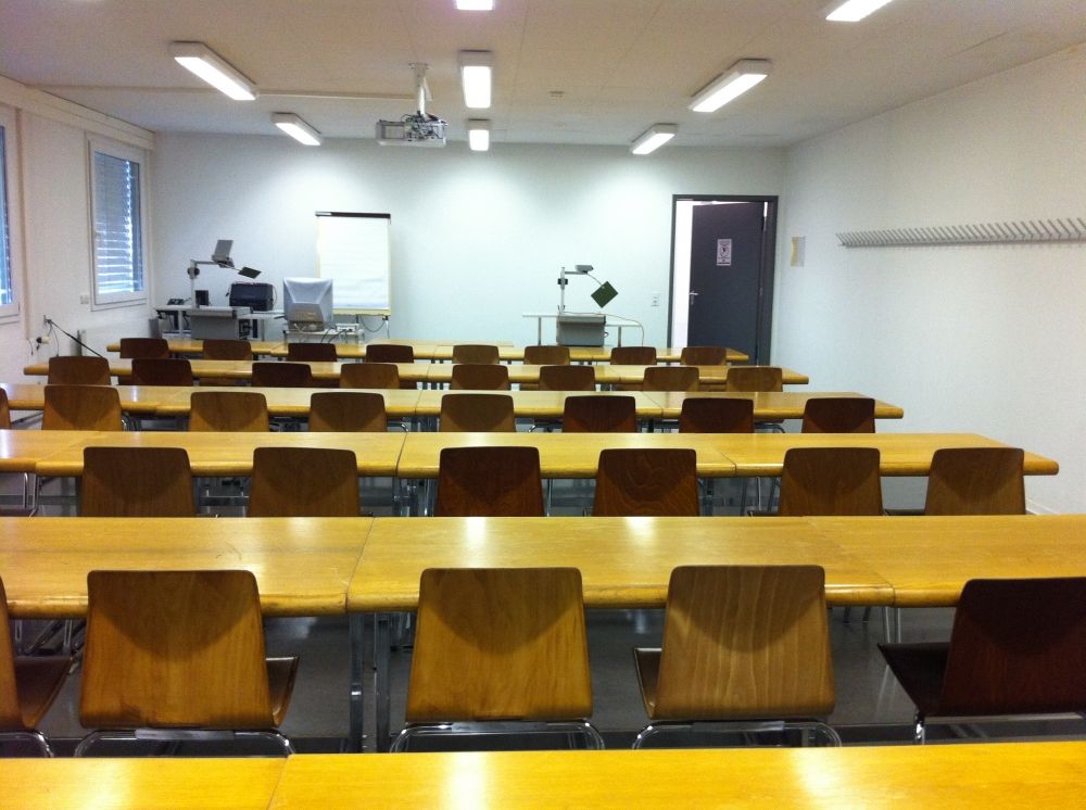 Seminarraum SOE-F-02: In Richtung Flipchart. Rechts Eingangstüre erkennbar.