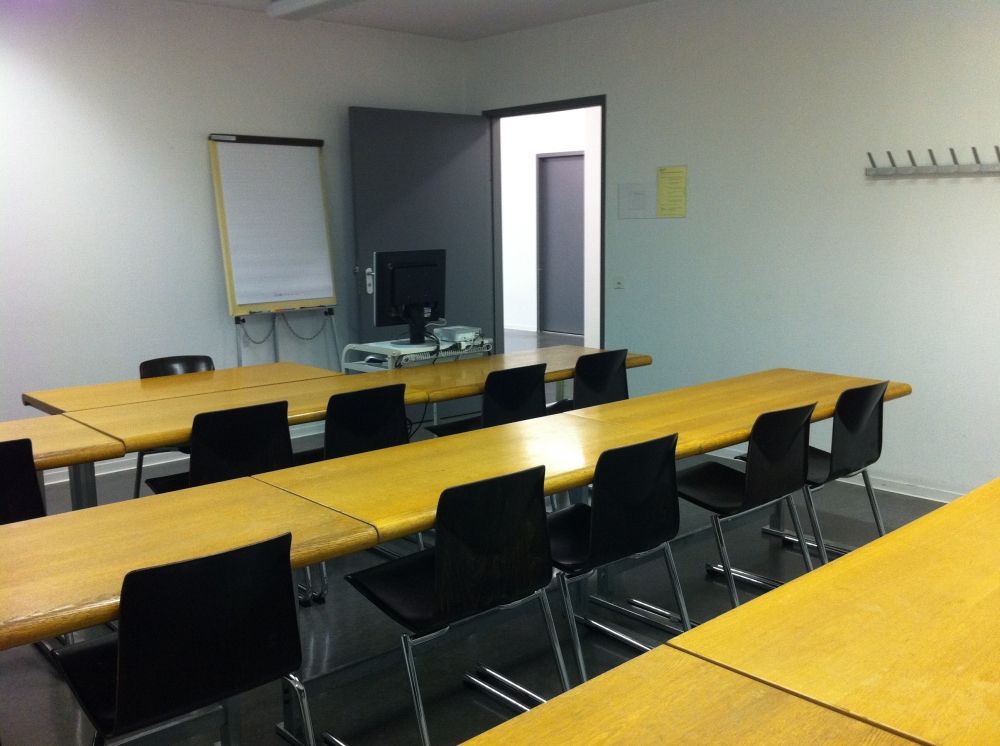 Seminarraum SOE-F-09: In Richtung Flipchart. Eingangstüre rechts erkennbar.