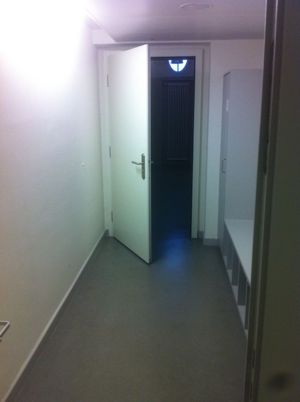 Ruheraum KOL-Q-2: Sicht auf die zweite Zugangstüre und rechts die Sitzbank mit den Schuhfächern.
