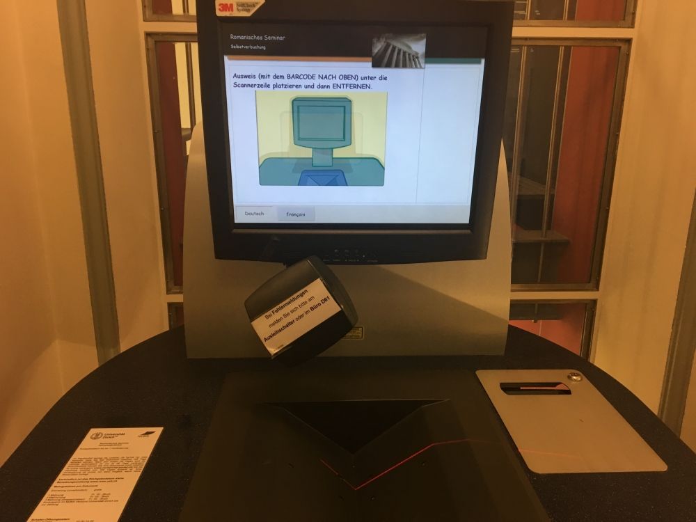 ZUG, Stockwerk D: Selbstverbuchungsgerät im Eingangsbereich (Stehtisch; Höhe ca. 110cm). Hier kann man die Dokumente unabhängig von der Öffnungszeiten der Bibliothek selbst ausleihen mit der Legi.