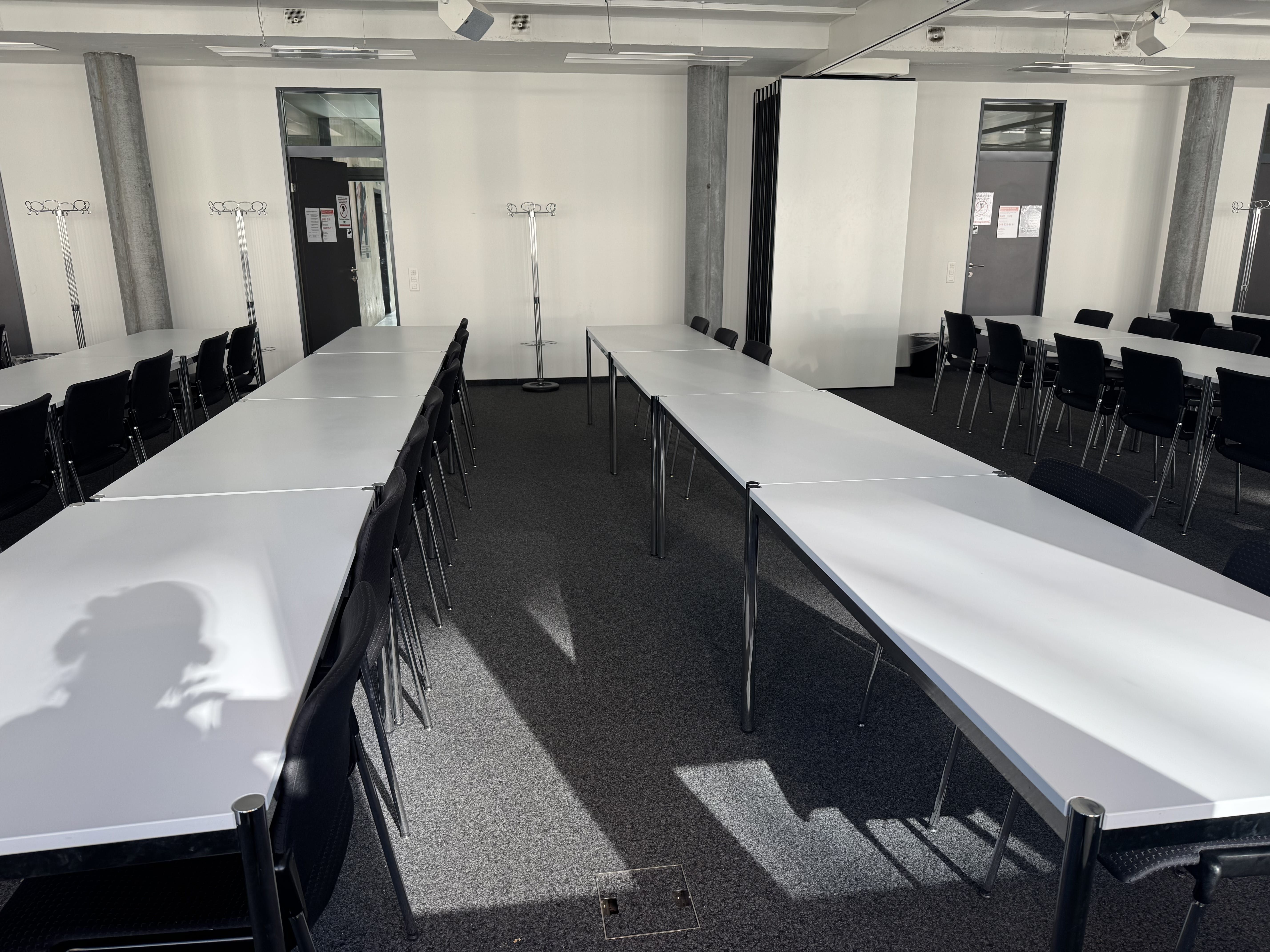 Seminarraum AND-03-06: Ansicht auf den Raum von der gegenüberliegenden Seite zur Eingangstüre. Die Faltwand befindet sich auf der rechten Seite.