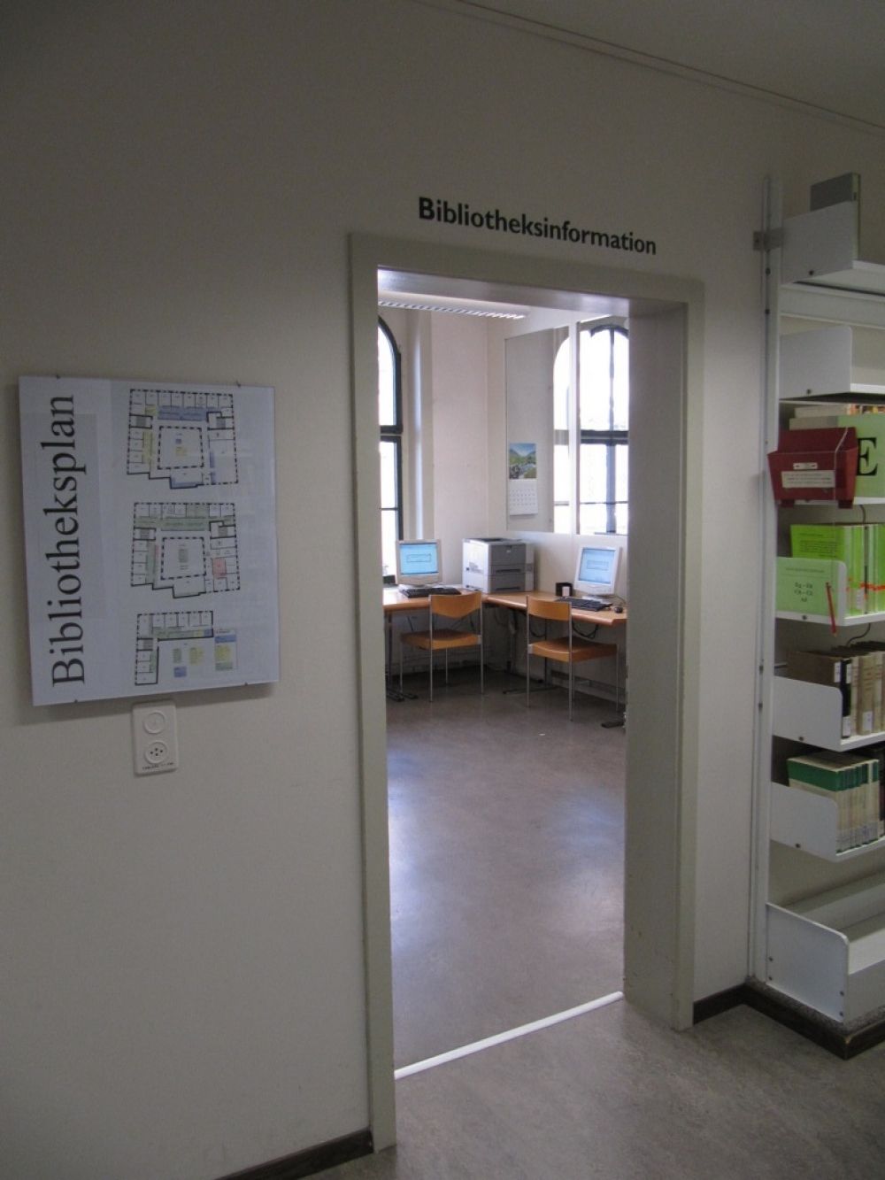 KIR-1, Bibliothek: Eingangstür zum Zimmer 115 mit Blick auf die Recherchestation und die Selfcheckstation.