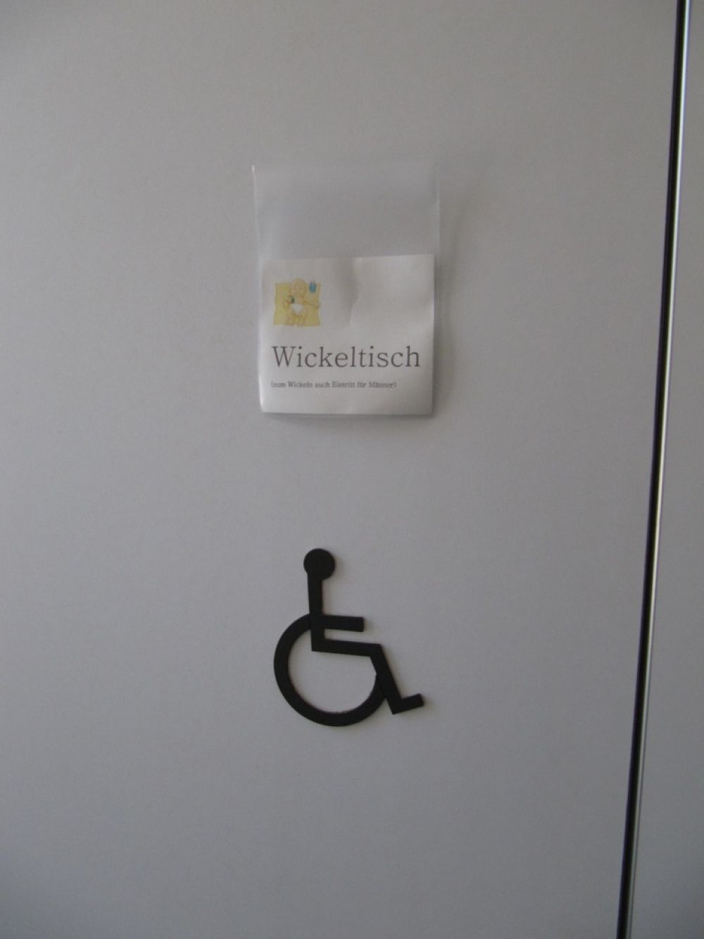 WC-Anlage KIR-1-108: Kabinentür zum Rollstuhl-WC und Wickeltisch.