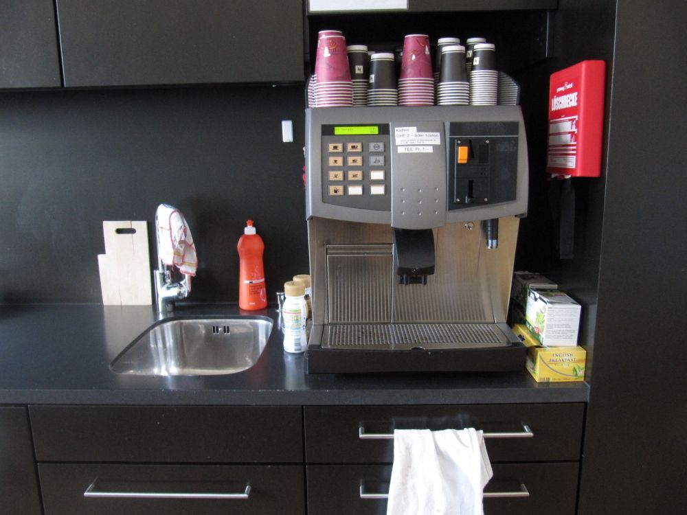 Aufenthaltsraum KAB-E-11: Kaffeeautomat mit Waschbecken.