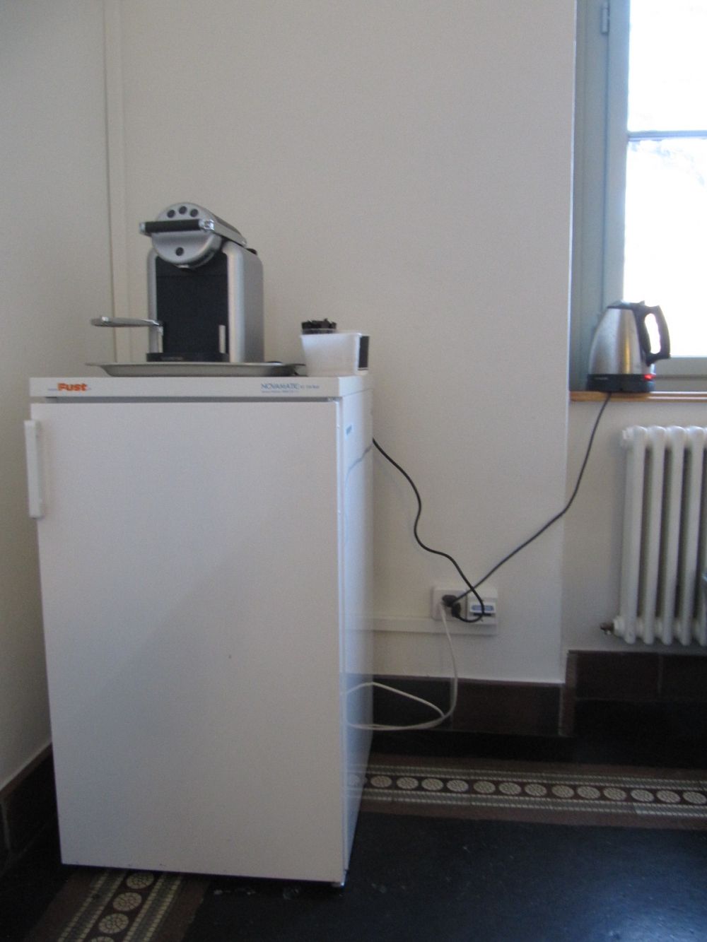 Sitzungsraum KAB-F-13: Die Kaffeemaschine auf dem Kühlschrank und ein Wasserkocher.