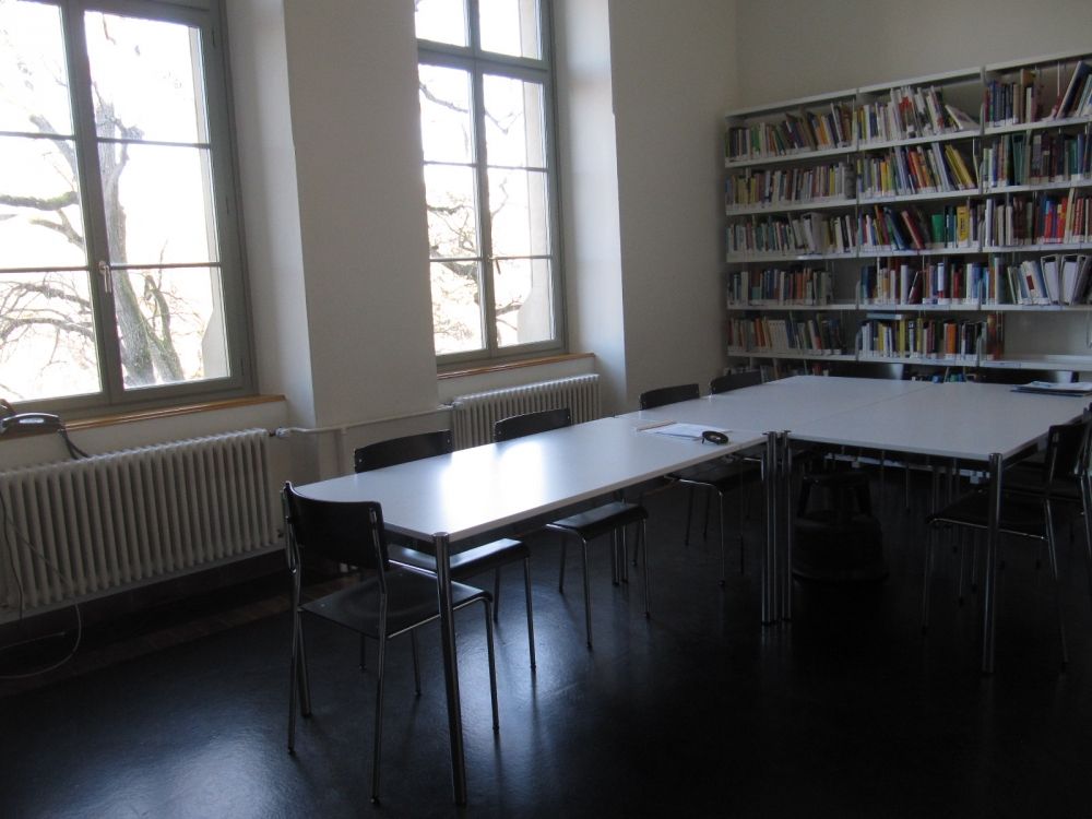 Sitzungsraum KAB-G-12: Besprechungsraum mit Bücherregal vom Eingang her.